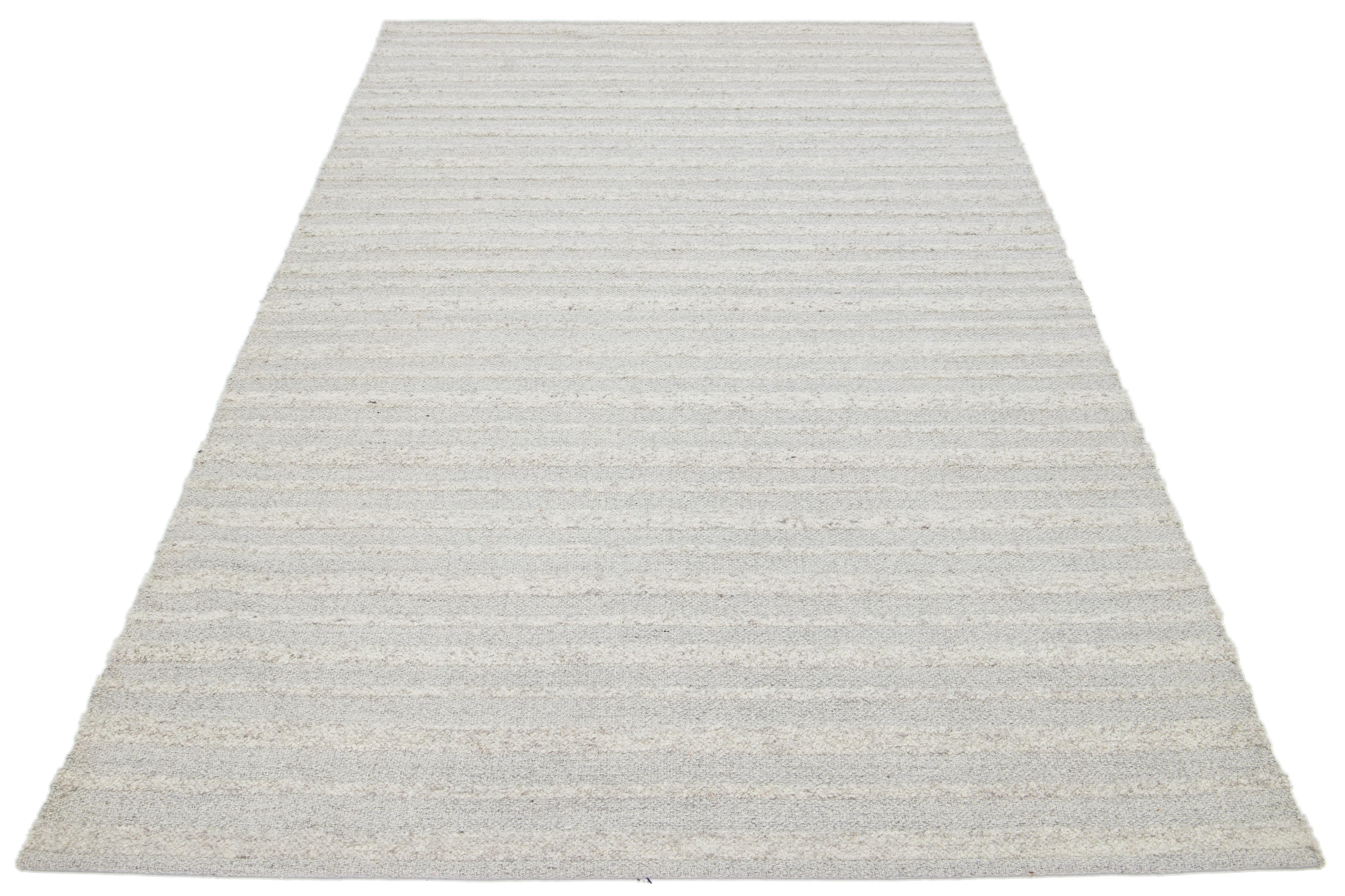Dies ist ein schöner Kelim handgefertigt Wolle Teppich mit einem beige Feld. Dieser maßgefertigte moderne Flachgewebe-Teppich aus unserer Nantucket Collection hat graue Akzente und ein wunderschönes geometrisches Allover-Muster.

Dieser Teppich