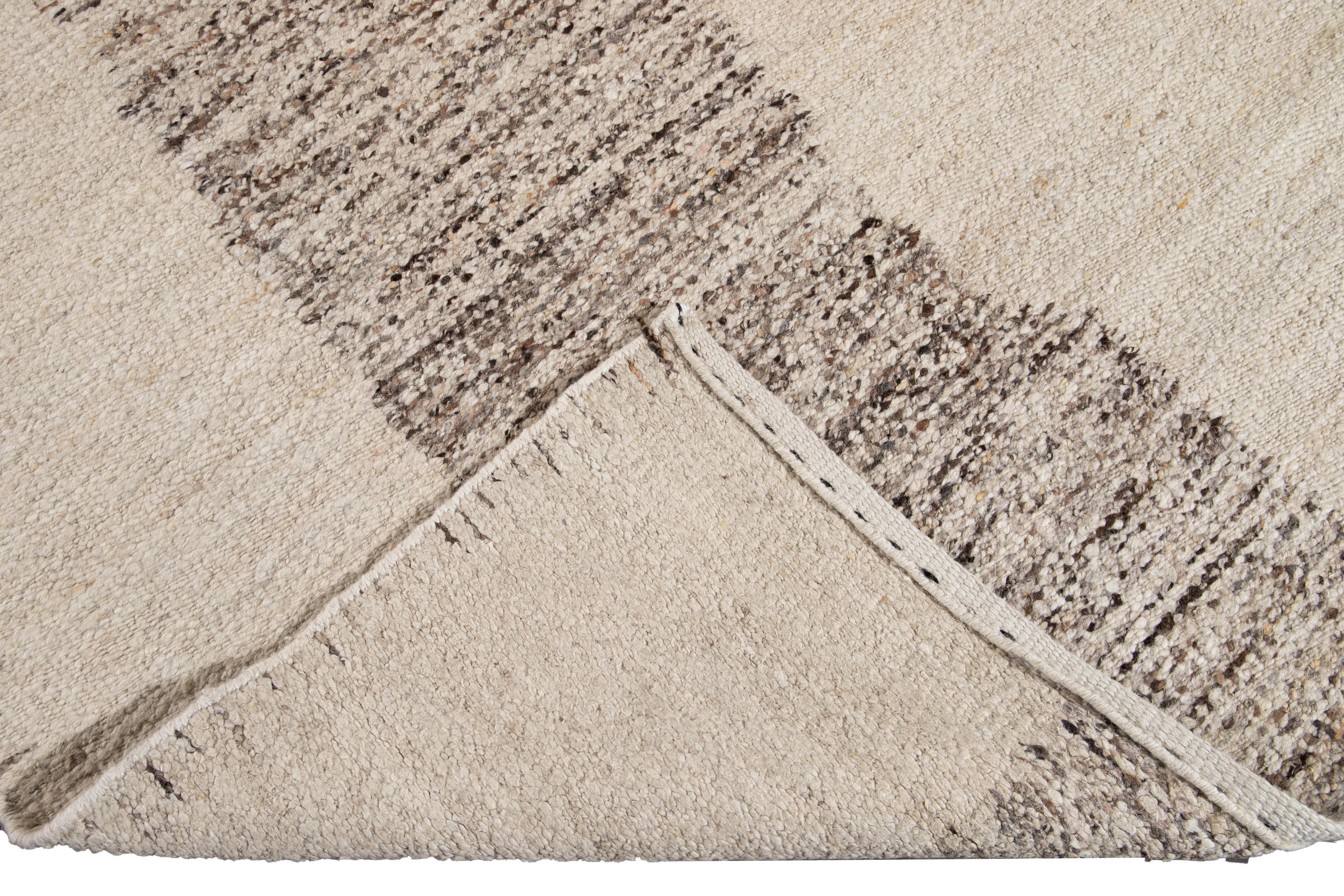 Schöner handgefertigter Wollteppich im marokkanischen Stil mit beigem Feld. Dieser marokkanische Teppich hat braune und beigefarbene Akzente in einem herrlichen geometrischen Muster.

Dieser Teppich misst: 12' x 14'10