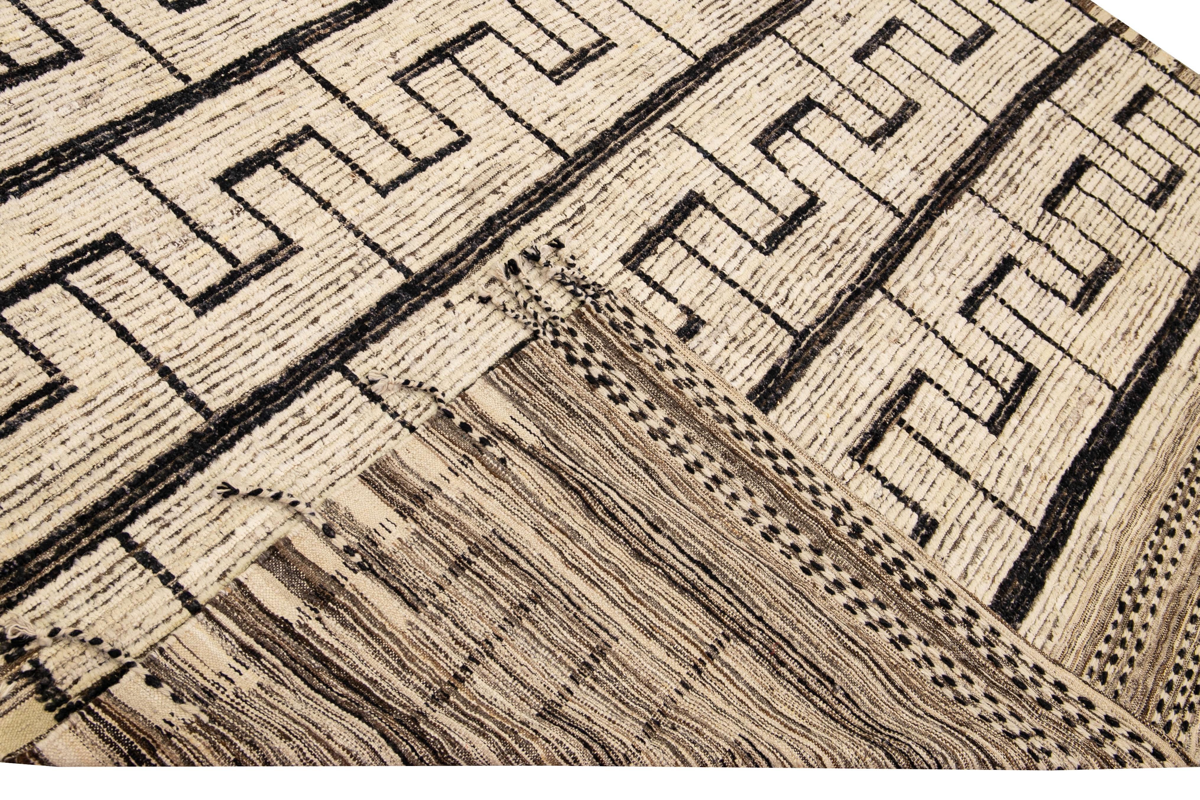 Beautiful Moroccan style handmade wool rug with a beige and brown field. This Modern rug has black and brown accents and beige-black braid fringes featuring a gorgeous all-over geometric boho design.

This rug measures: 9' x 12'6