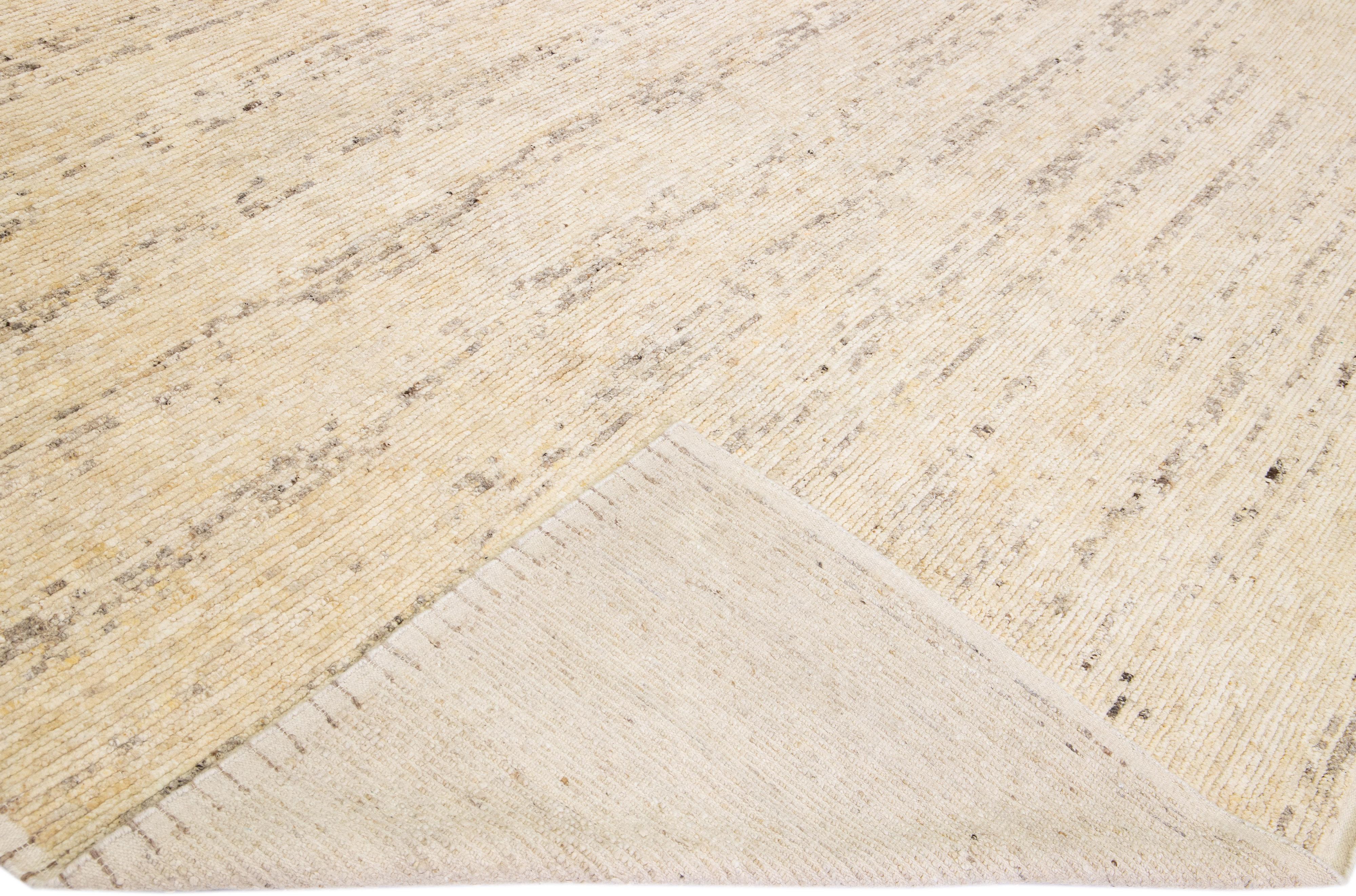 Bellissimo tappeto in lana fatto a mano in stile marocchino con campo beige. Questo tappeto moderno ha degli accenti grigi con uno splendido disegno a strisce all-over.

Questo tappeto misura: 12'1