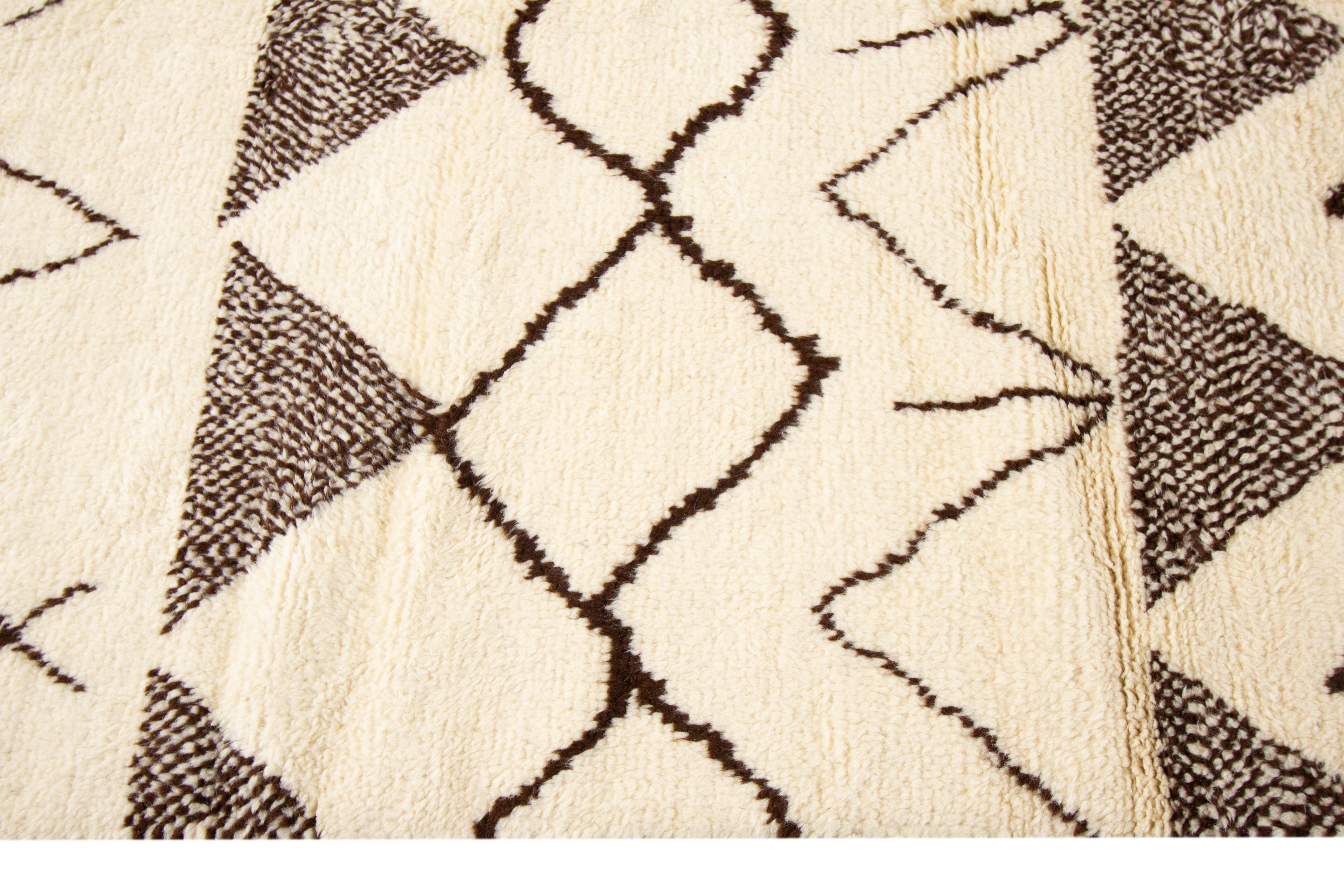 A hand-knotted modern Moroccan-style rug featuring a tribal design. This rug has a beige field with brown accents.

This rug measures 9'6