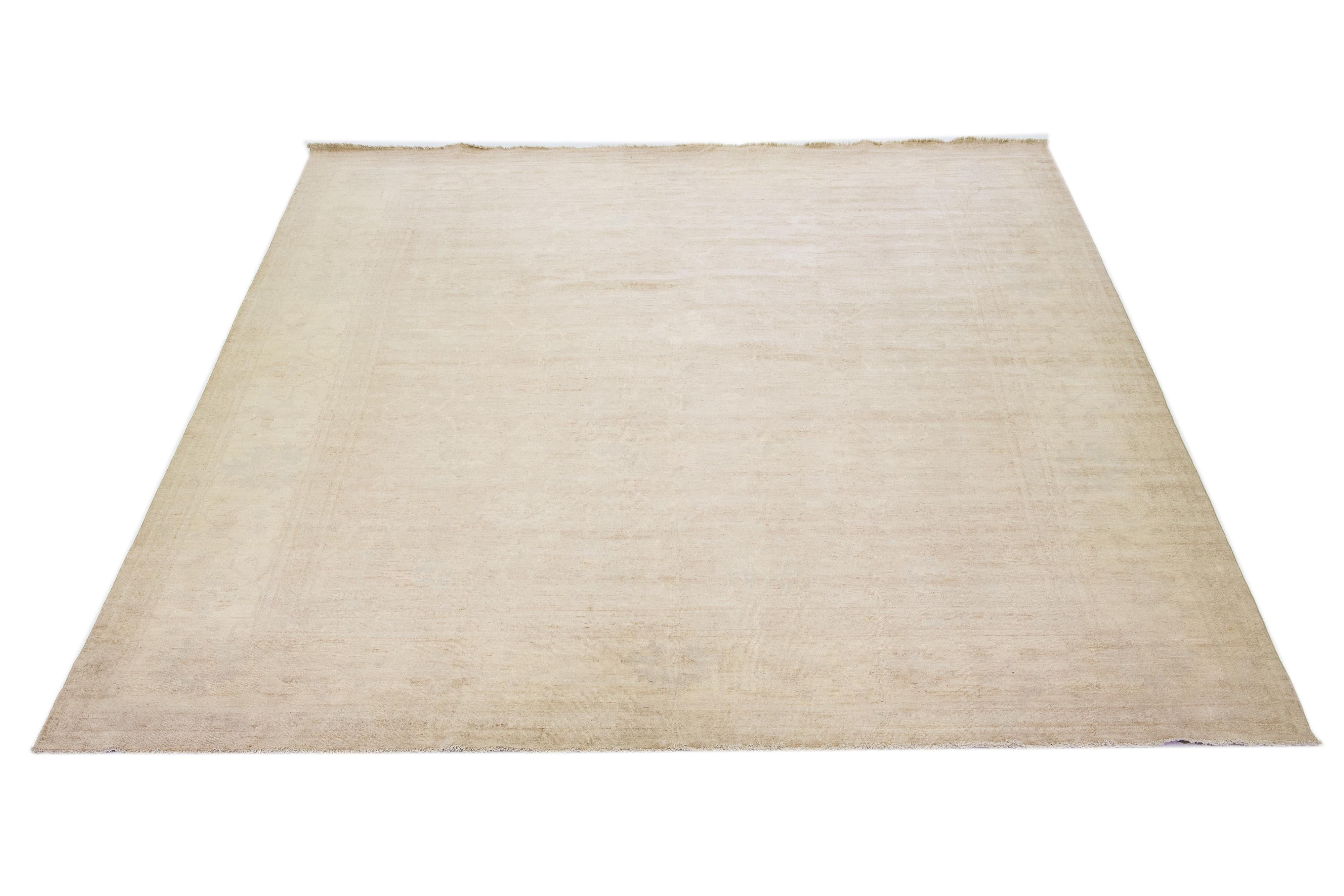 Beautiful modern Oushak hand-knotted wool rug with a beige color field. This Piece has gray accent colors in a gorgeous all-over floral design.

This rug measures: 12' x 14'4
