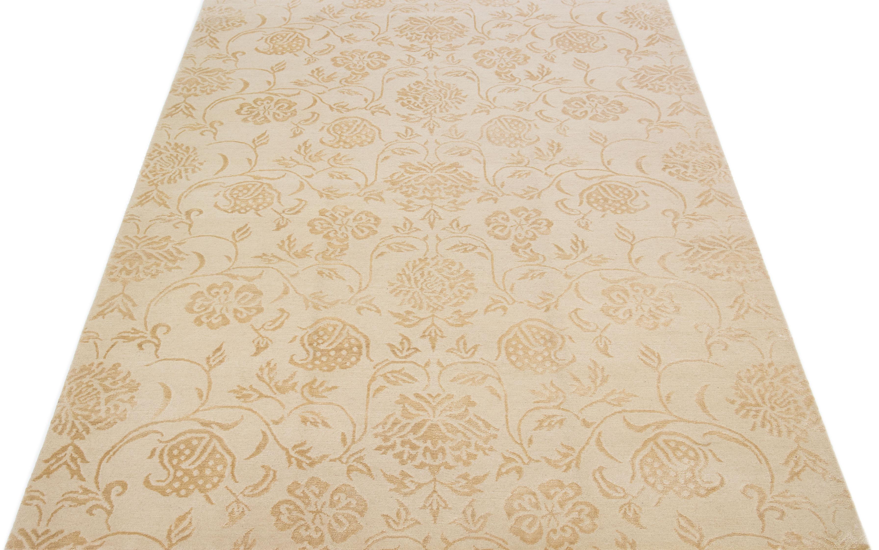 Crafted from premium quality wool and silk, this contemporary Nepalese rug features an intricate all-over scroll floral design in stunning shades of rich beige, beautifully accentuated by luxurious golden details.

This rug measures 6' x 9'1