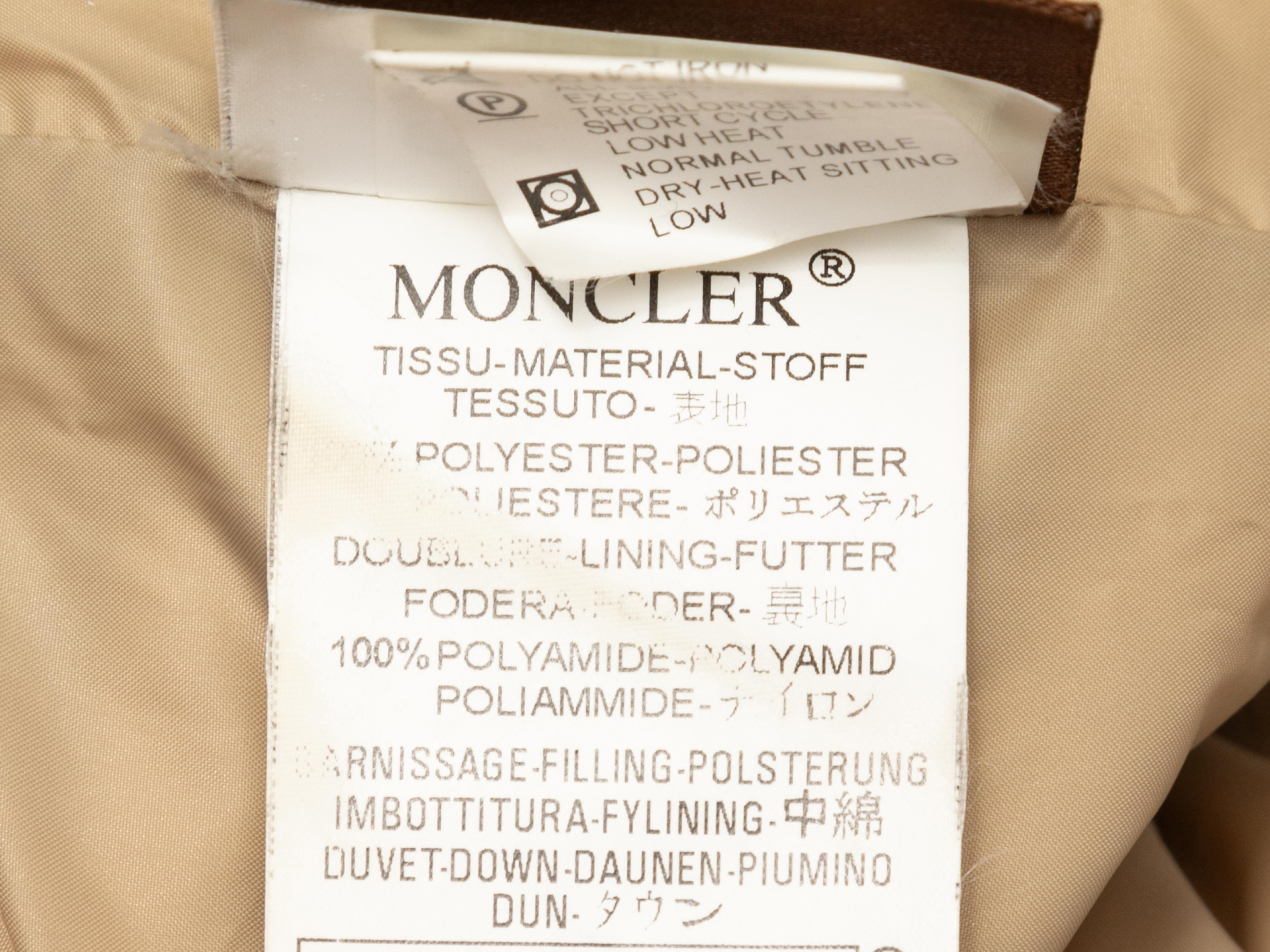 Beige fur-trimmed hooded down puffer coat by Moncler. Dual hip pockets. Front zip and snap closures. 38