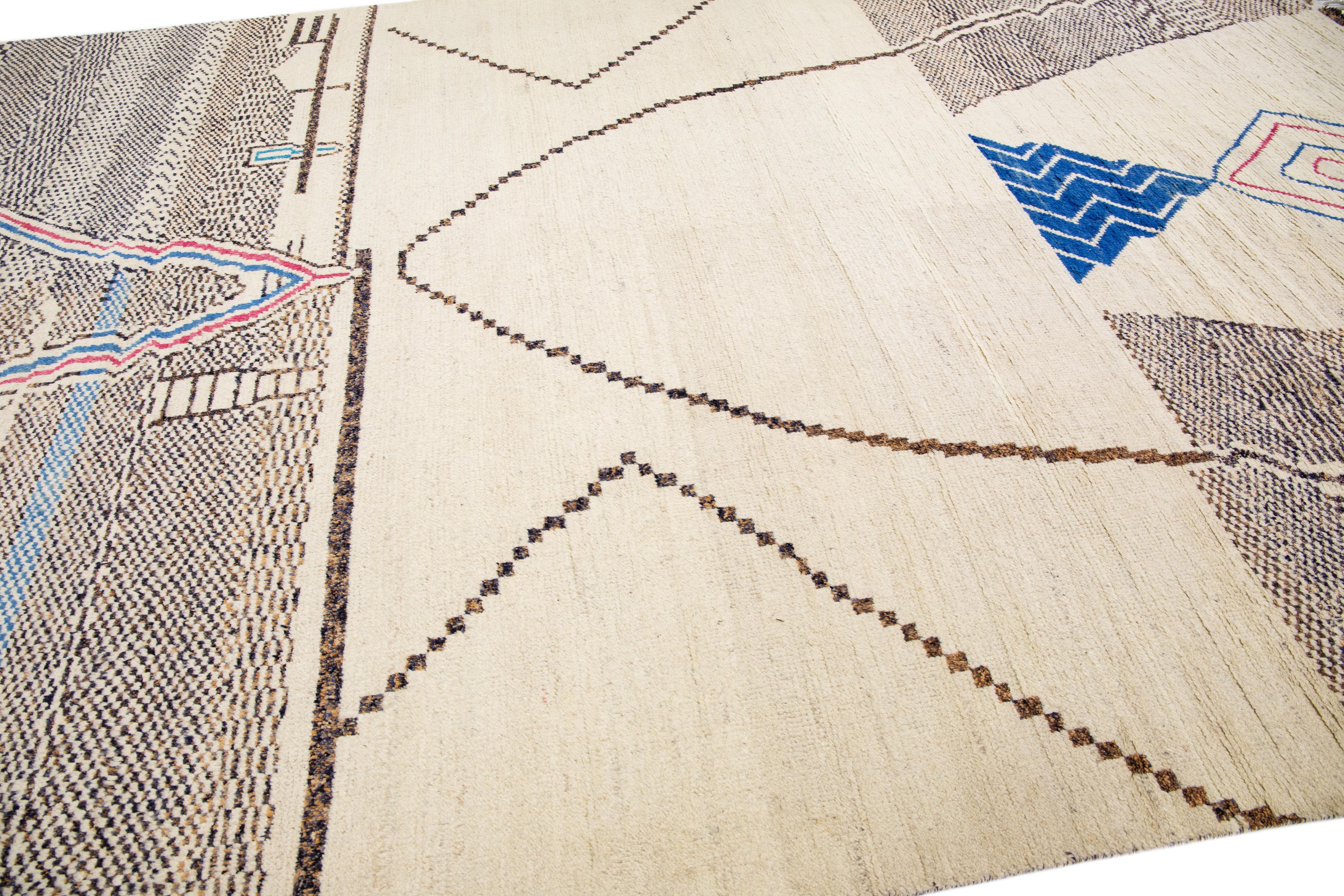 Beautiful moroccan berber style hand-knotted wool rug with a beige field. This piece has multicolor accents in an all-over geometric abstract design.

This rug measures: 10' x 14'8