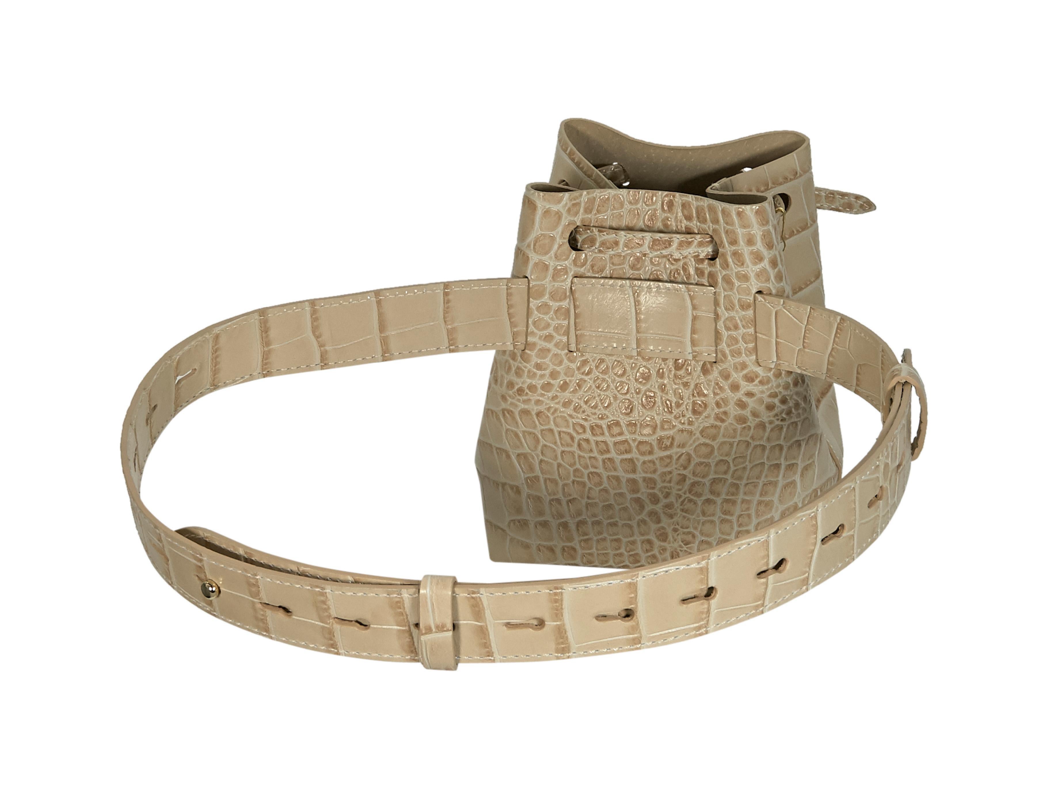 Product details:  Beige croc-embossed vegan leather Minee belt bag by Nanushka.  From the FW18 collection.  Drawstring top closure.  Adjustable waistband.  Goldtone hardware.  6.5