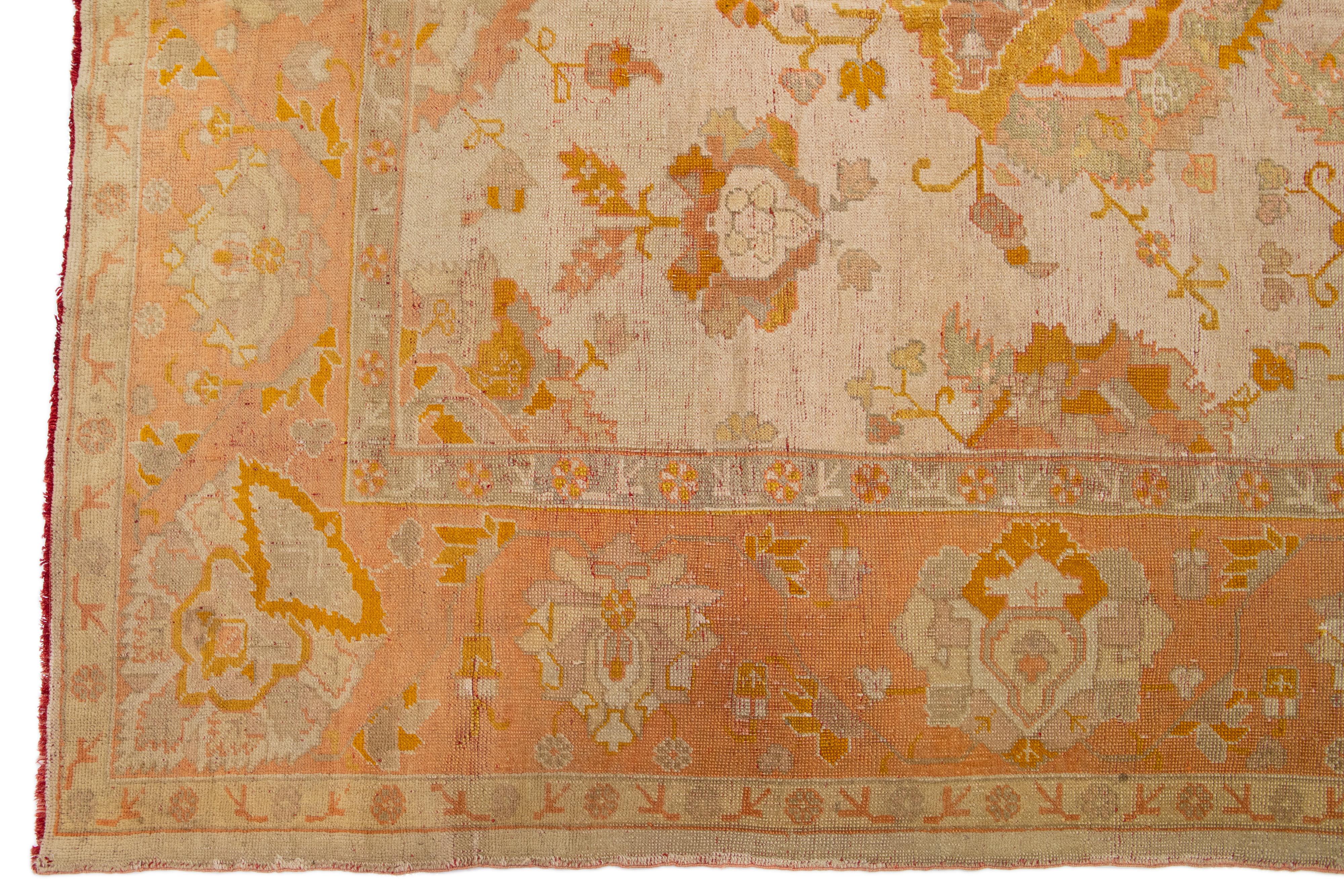 Beautiful Antique Turkish hand-knotted wool rug with a beige color field. This rug has an orange- peach designed frame with accent colors of goldenrod and gray in a gorgeous all-over geometric floral design.

This rug measures: 12'3
