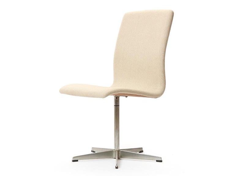 A Scandinavian Modern 'Oxford' chair in beige upholstery with a low back on a cast aluminum five point base. Designed by Arne Jacobsen, made by Fritz Hansen, Denmark, 1965.  Listed price is per chair. Six chairs available.

Arne Jacobsen was a