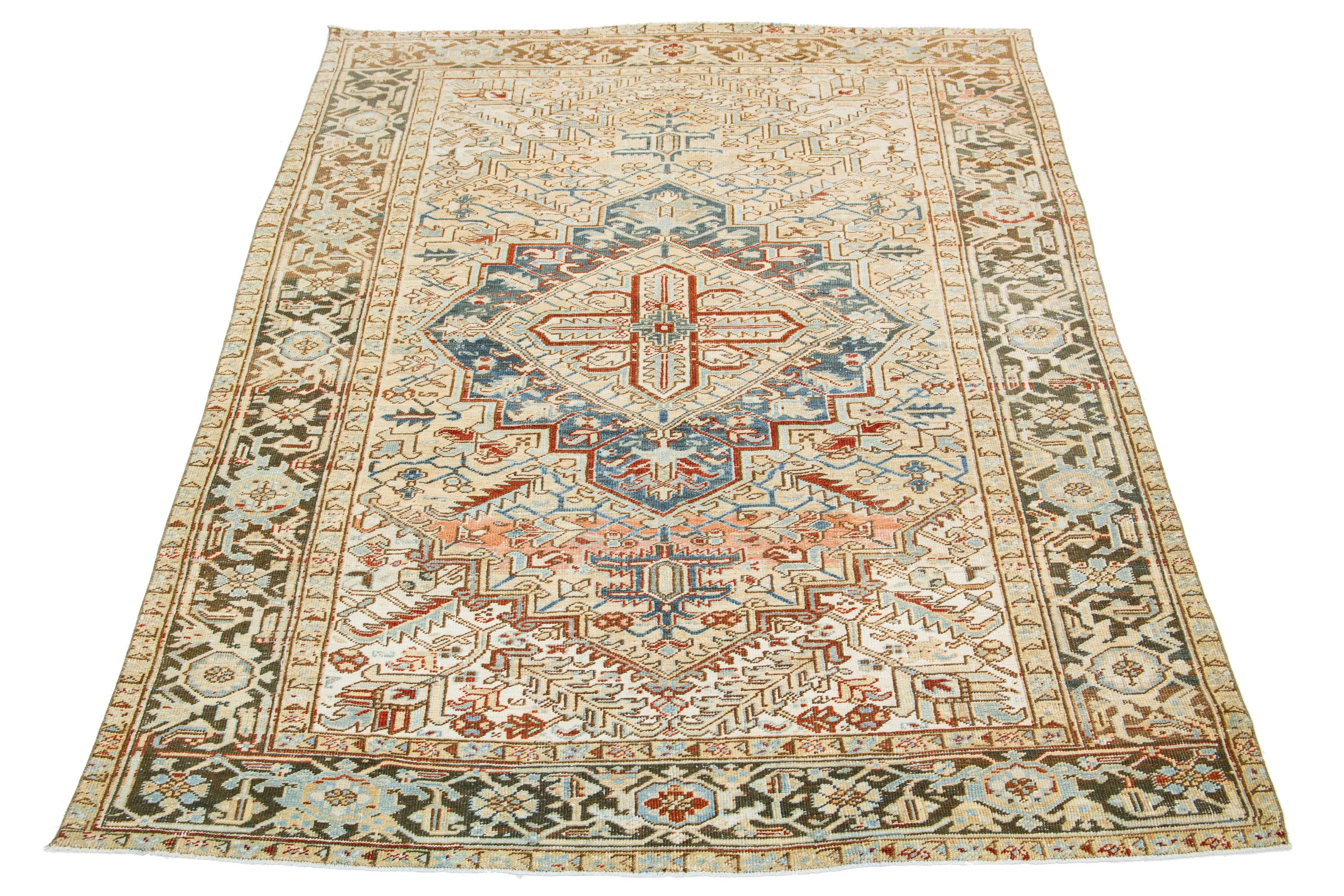 This antique Persian Heriz rug is made with hand-knotted wool. The beige field showcases a captivating allover pattern adorned with blue, rust, brown, and ivory shades.

This rug measures 6'2' x 8'9