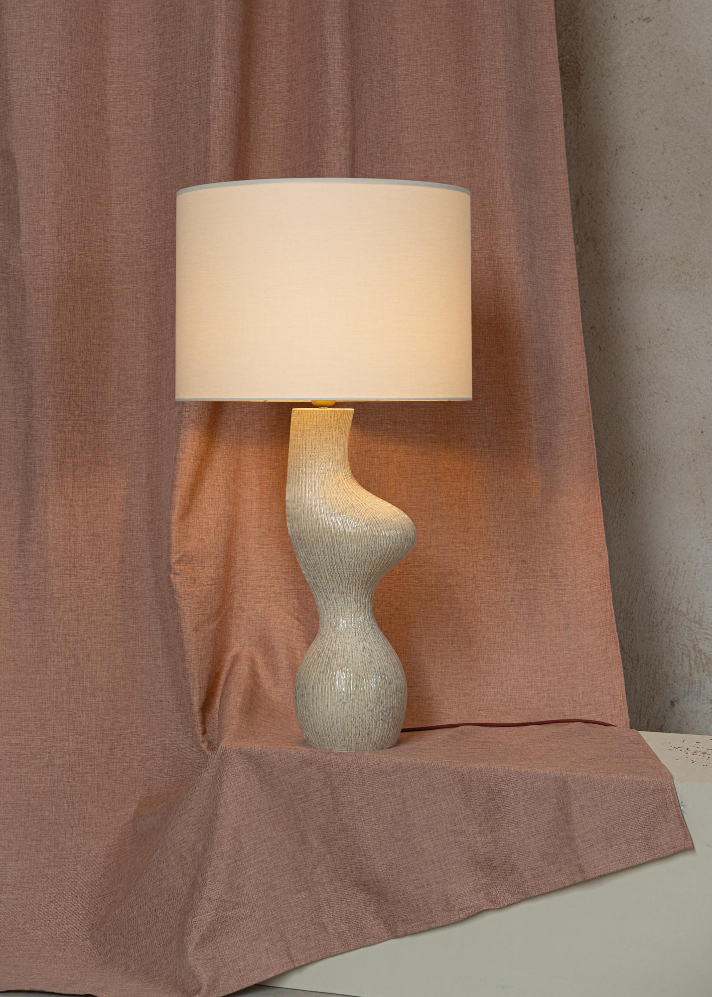 Beige Ribbed Ceramic Venuso Table Lamp by Simone & Marcel
Dimensions: Ø 50 x H 78 cm.
Materials: Cotton and ceramic.

Also available in different ceramic options. Custom options available on request. Please contact us. 

All our lamps can be wired