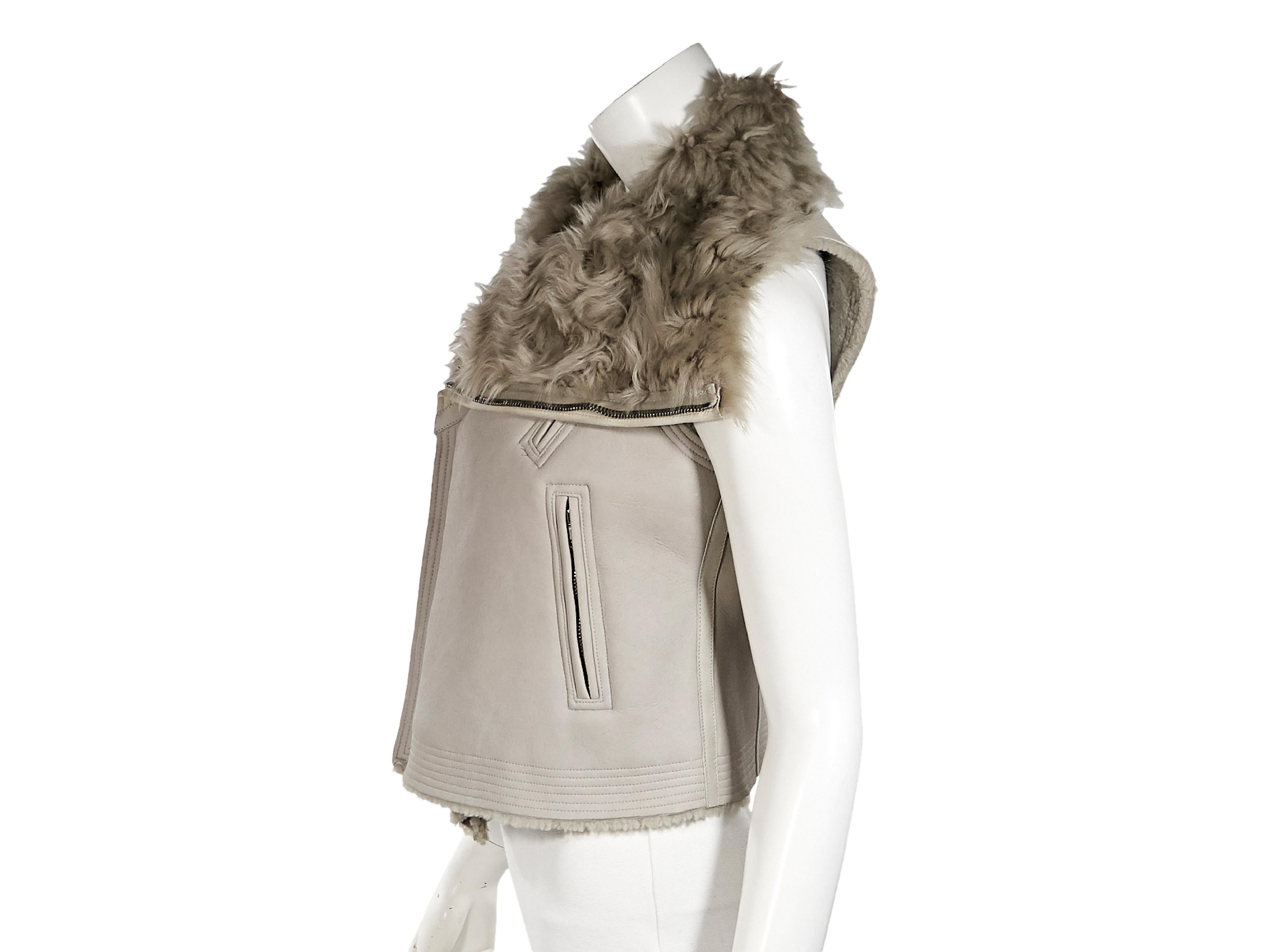 Product details:  Beige shearling vest by Rick Owens.  Asymmetrical zip-front closure.  Chest and waist zip pockets.  Silvertone hardware.  31