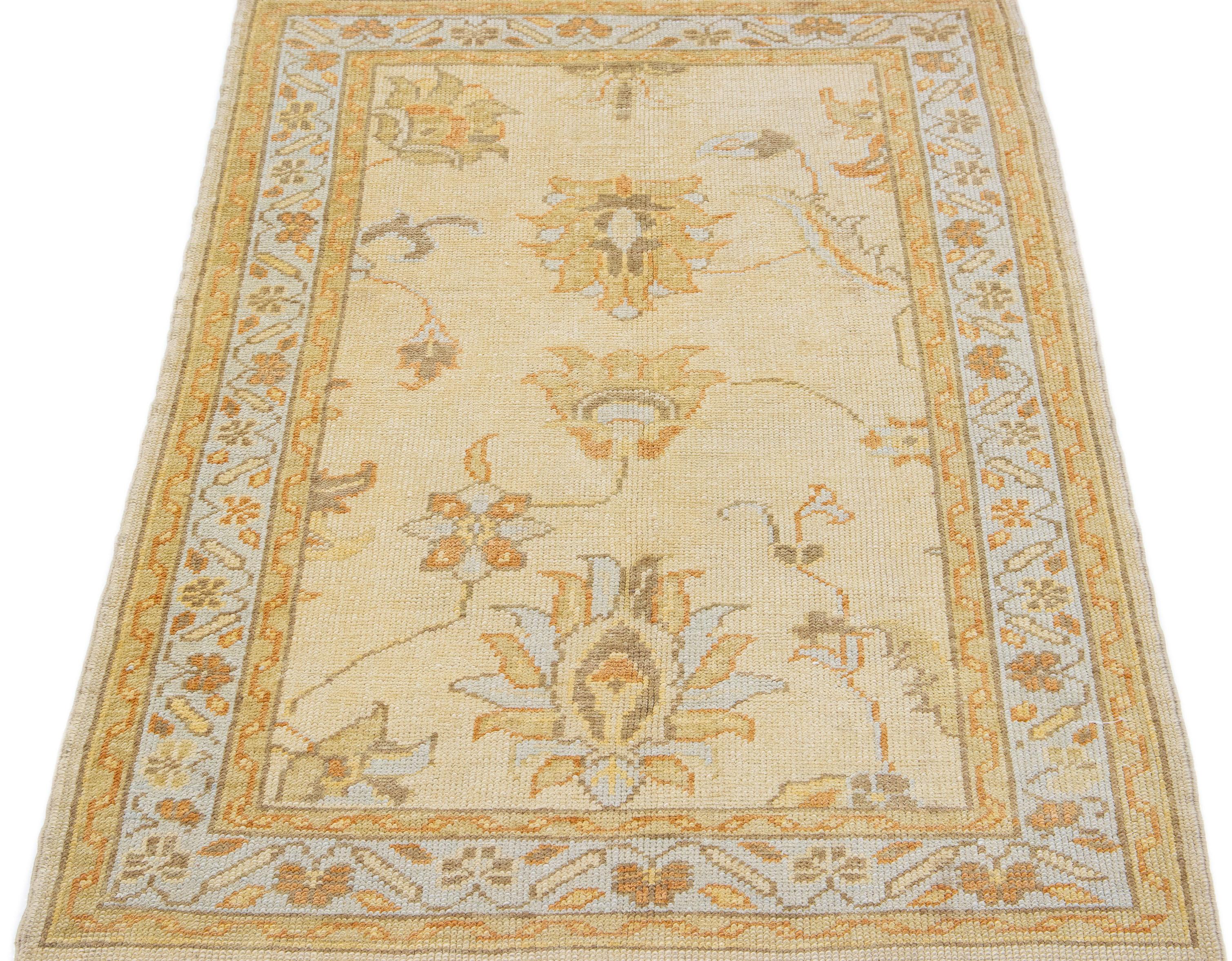 This woolen Oushak rug from Turkey boasts a modern aesthetic, featuring a delightful floral pattern in beige, gray, and orange shades.

This rug measures 3'6