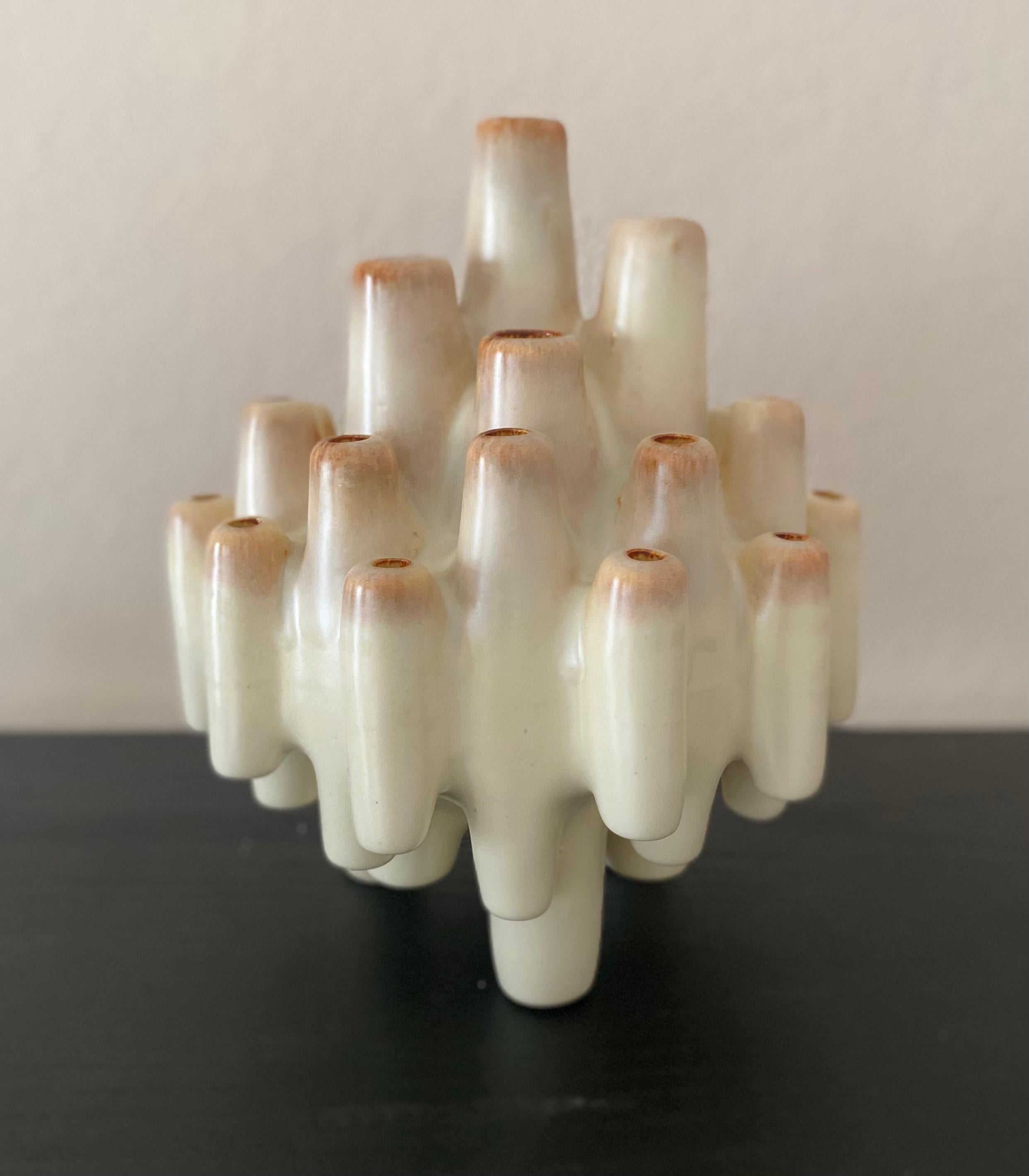 Remontez le temps jusqu'à l'atmosphère artistique des années 1960 avec ce remarquable vase sculptural en pique fleurs, fabriqué à la main par Bertoncello Ceramiche D'Arte en Italie. Ce vase, orné de teintes brunes, blanches, beiges et de cheminée,
