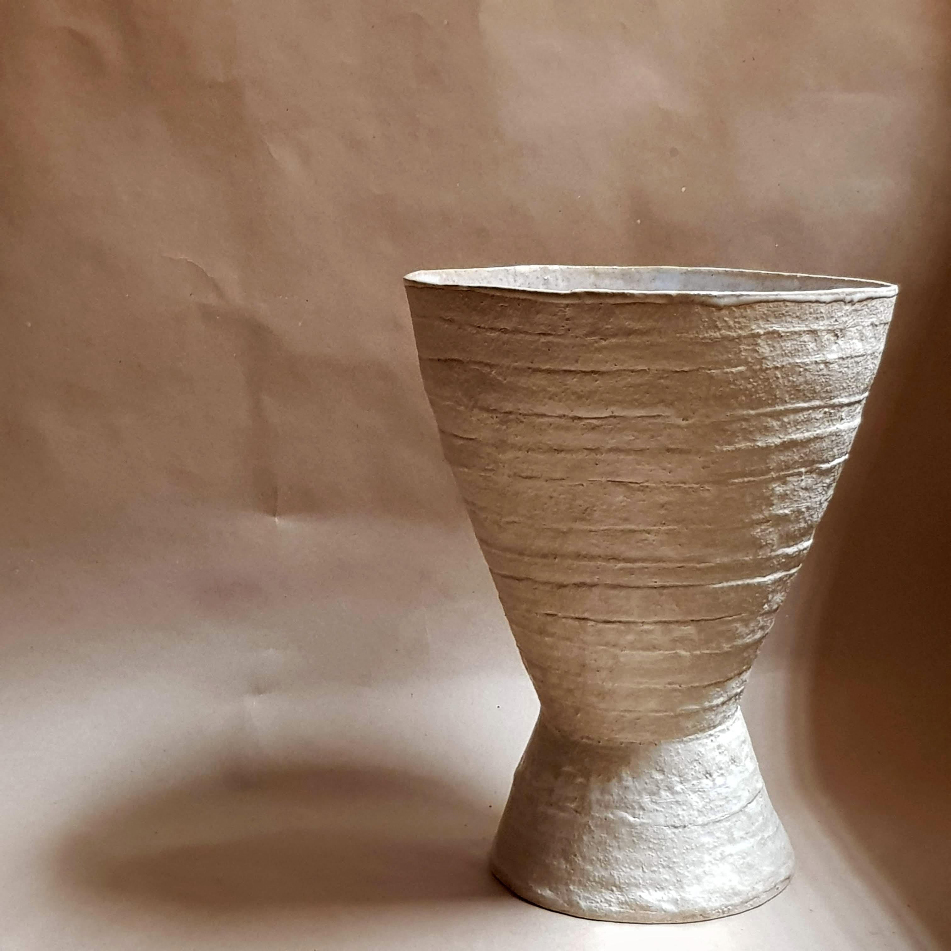 Beige Stoneware Krater Vase by Elena Vasilantonaki
Unique
Dimensions: ⌀ 25 x H 30 cm (Dimensions may vary)
Materials: Stoneware
Available finishes: Black, Beige, Brown, Red, White Patina. Interior glazed with Ash Glaze

Growing up in Greece I was