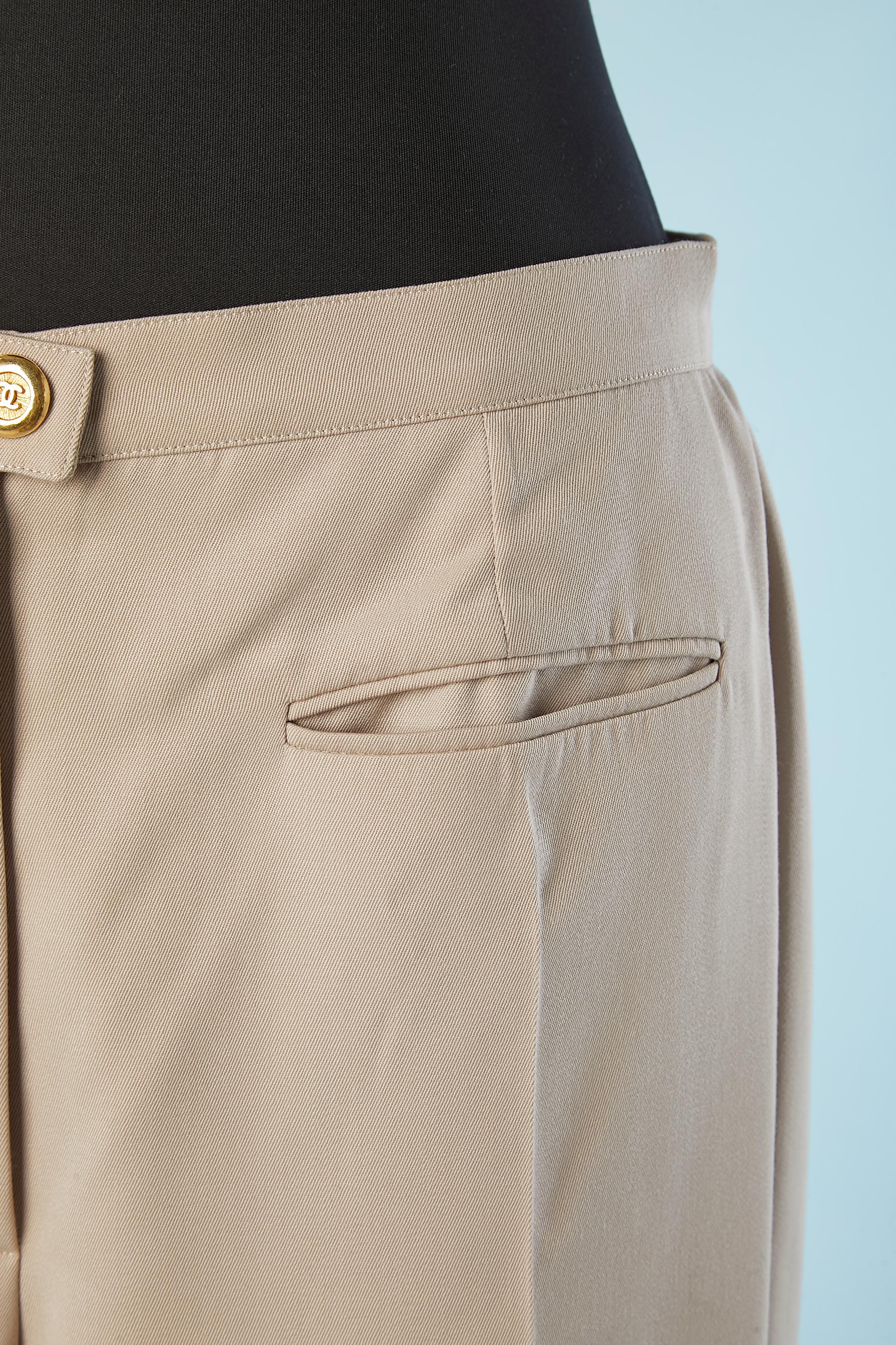 Beige thin wool trouser with branded buttons. Silk branded 