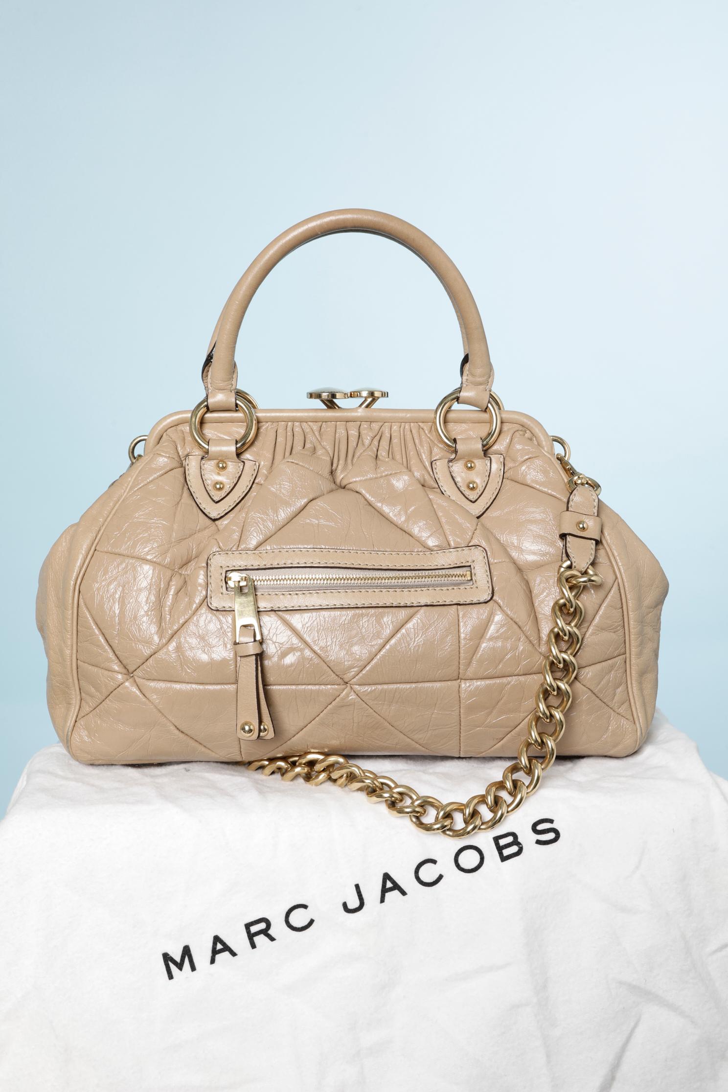 Bolso de piel beige pespunteada con bandolera de metal dorado.
Tamaño: 40 cm X 28 cm X 8 cm
Forro de tela. Se suministra bolsa antipolvo.