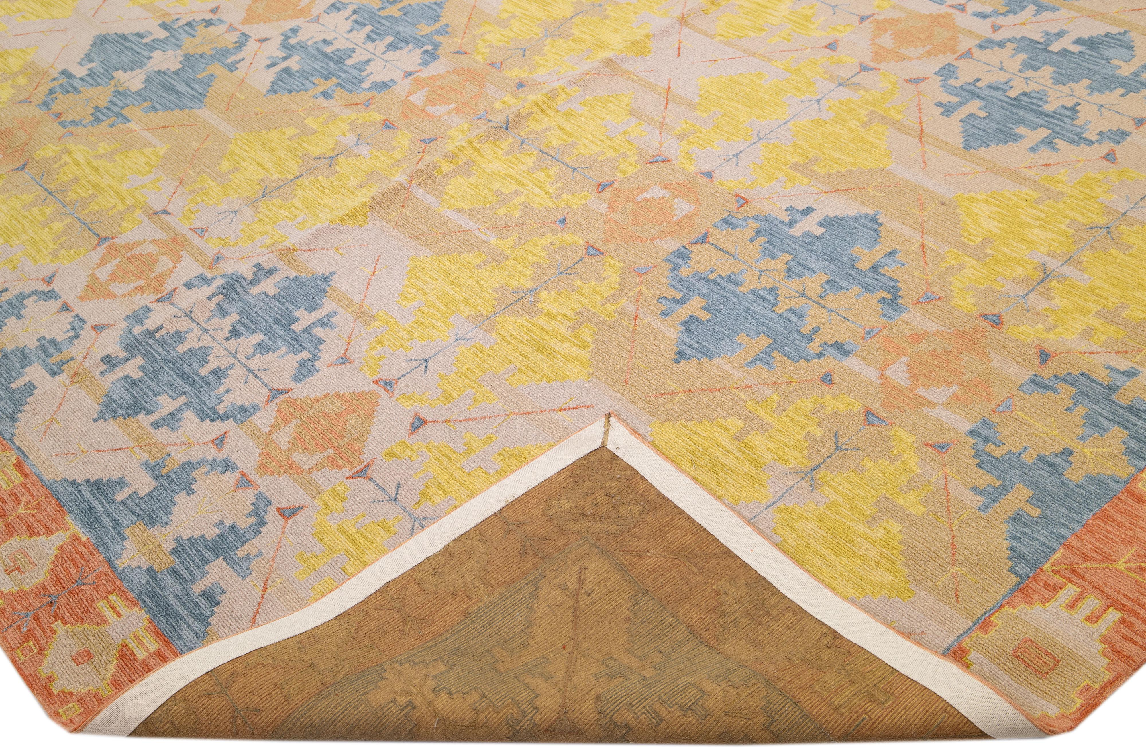 Beautiful Modern hand-knotted wool rug with a beige color field. This piece has a gorgeous blue, yellow, and orange accents layout in a transitional geometric design.

This rug measures: 14'9