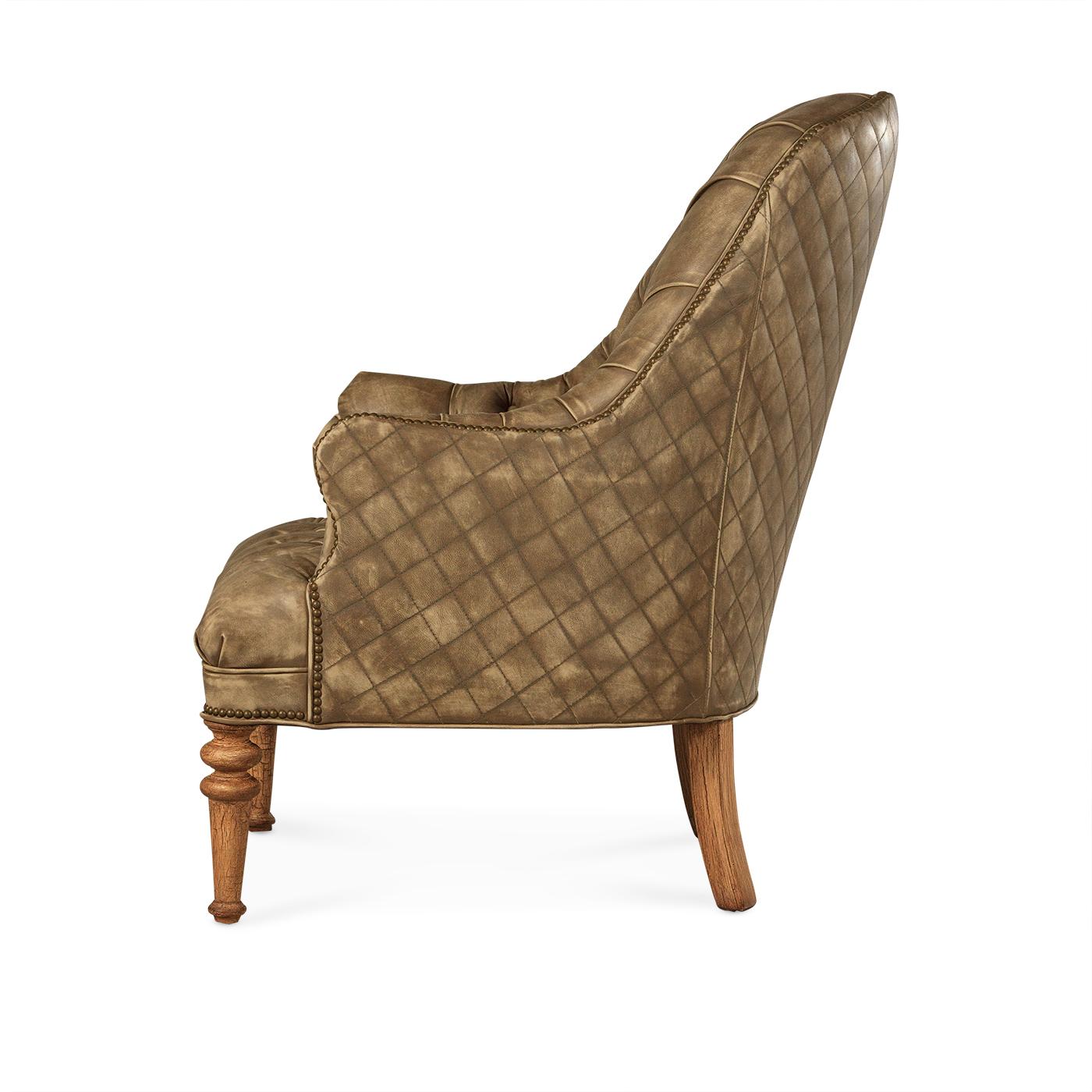An American Made classic beige tufted leather chair. With a deep tufted arched backrest, seat, and arms. These accent chairs have a unique opposing diamond quilted pattern outside. With natural brass nailhead trim details, it is raised on turned and