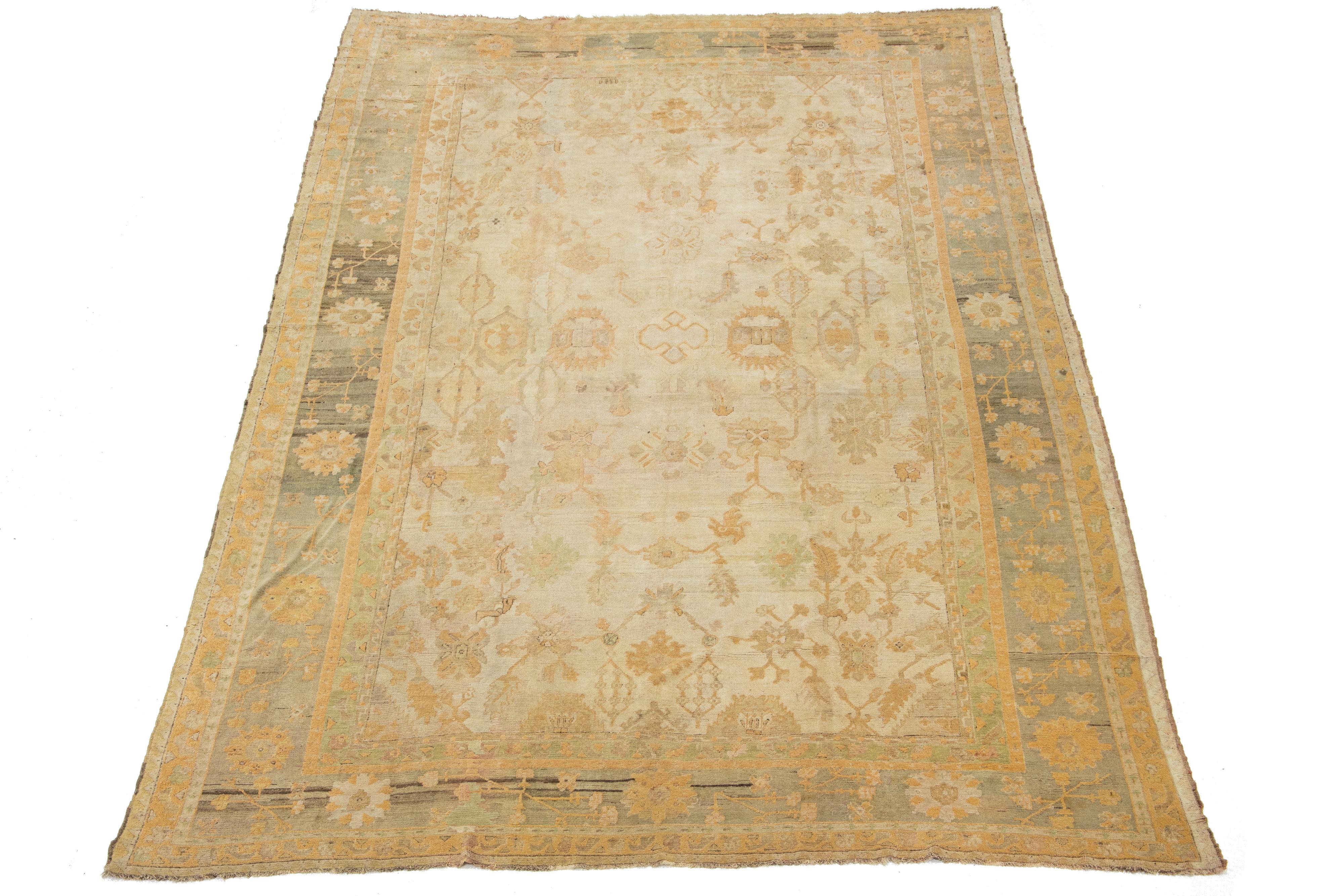 Dieser einzigartige türkische Oushak-Teppich ist aus weicher Wolle handgeknüpft und hat eine beige Farbgebung. Es zeigt ein wunderschönes Allover-Muster, das von einem dekorativen Rahmen umgeben ist und mit auffälligen Grün- und Goldrutentönen
