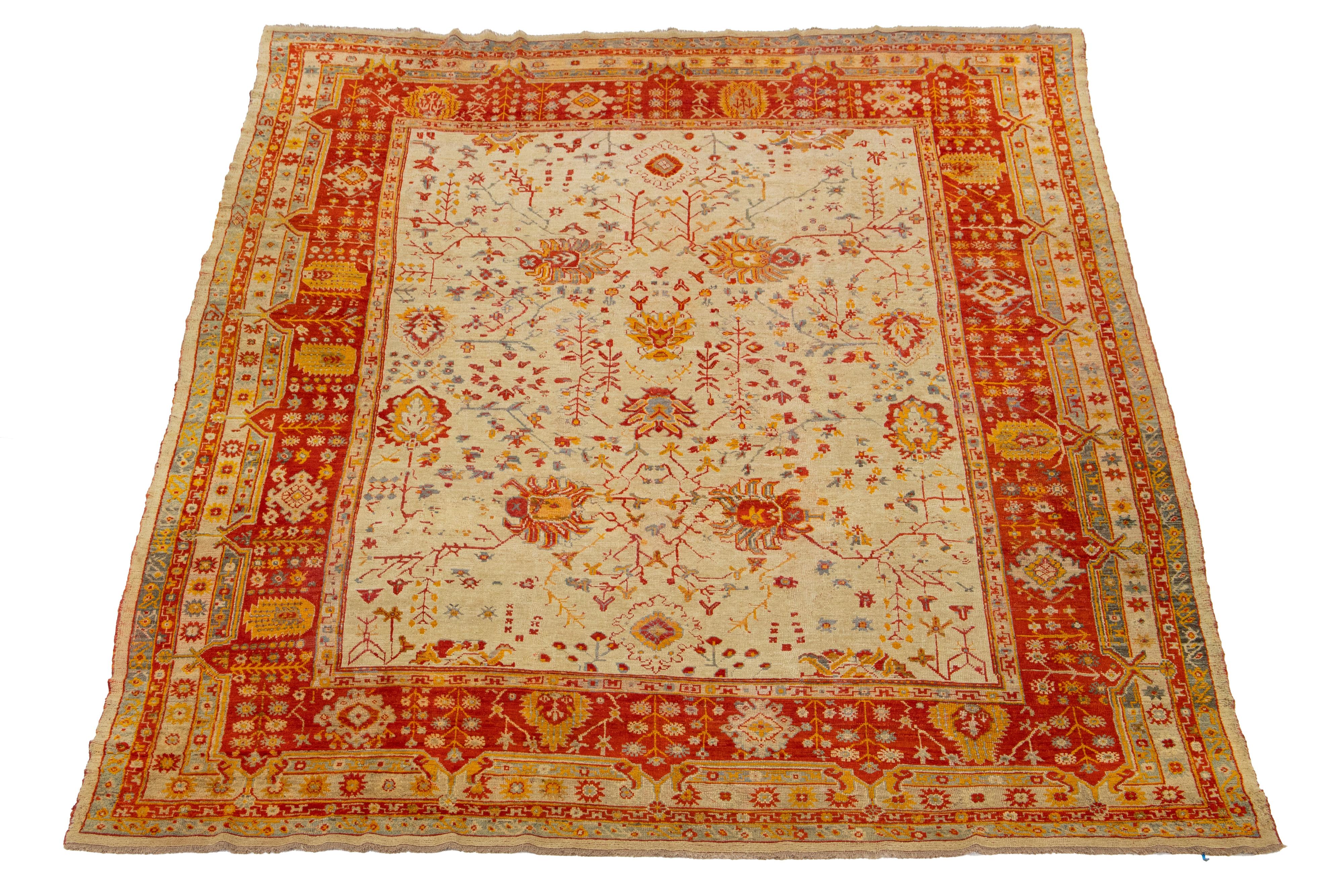 Dieser türkische Oushak-Teppich ist wirklich einmalig! Er ist aus weicher Wolle handgeknüpft und besticht durch ein wunderschönes beigefarbenes Farbfeld, das das auffällige florale Allover-Muster mit seinen auffälligen orangen, roten und grauen