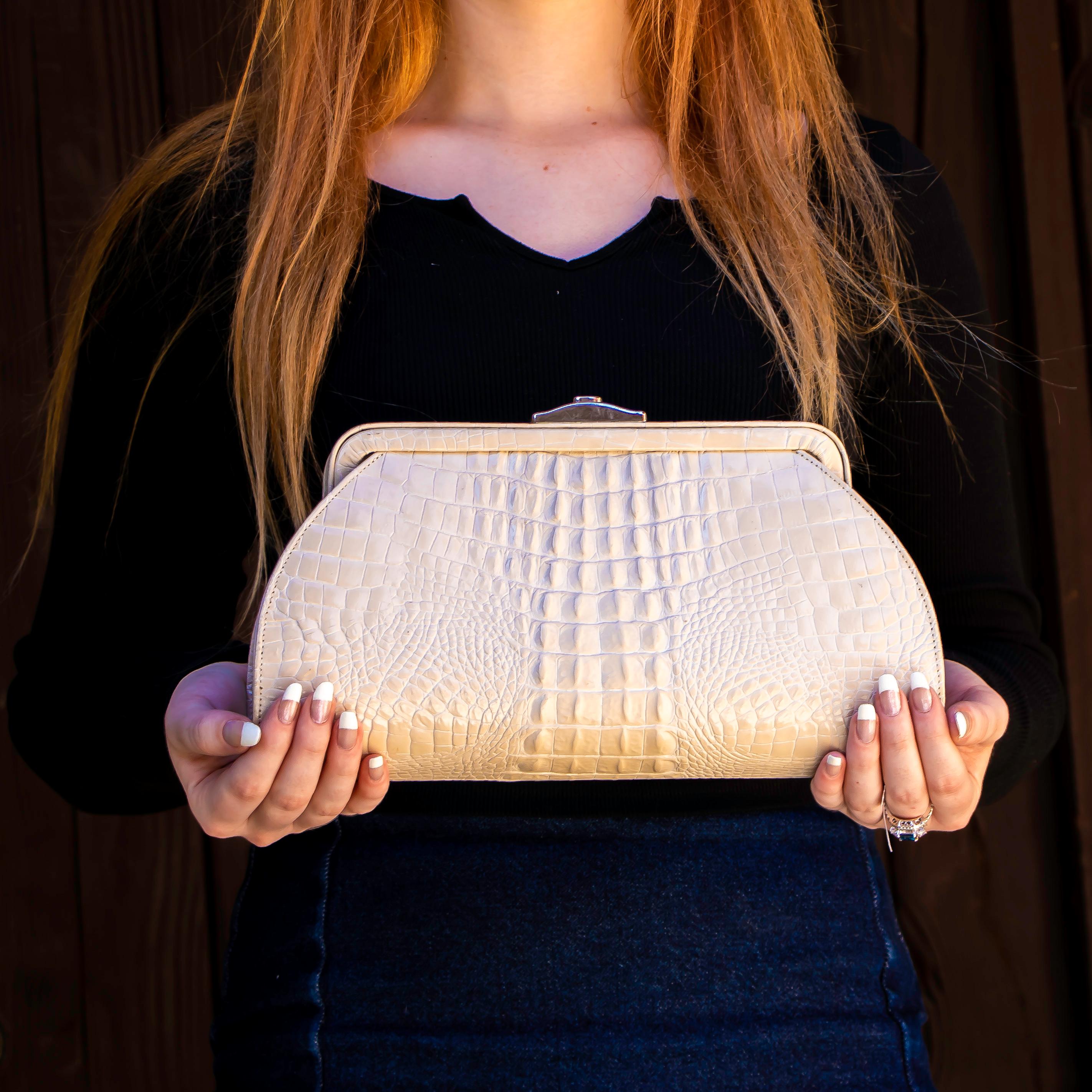 This large beautiful clutch has one spacious main pocket with an interior side pocket. This clutch has a push clip at the top and is made of crocodile back. Perfect for the everyday user. 

Height = 6.5 inches
Width = 12 inches
Depth = 3 inches