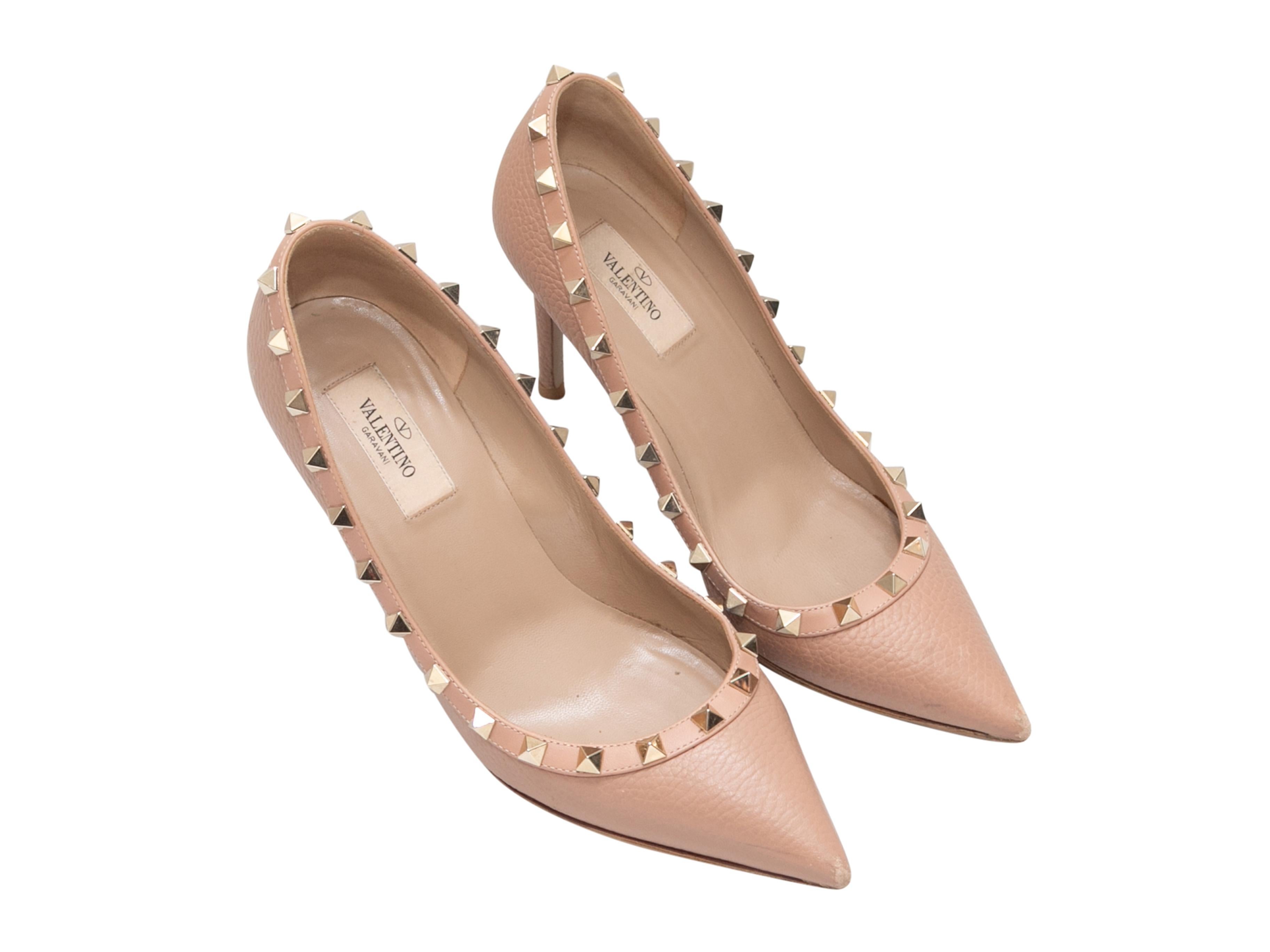 Beige pebbled leather pointed-toe pumps by Valentino. Gold-tone Rockstud trim at tops. 3.5