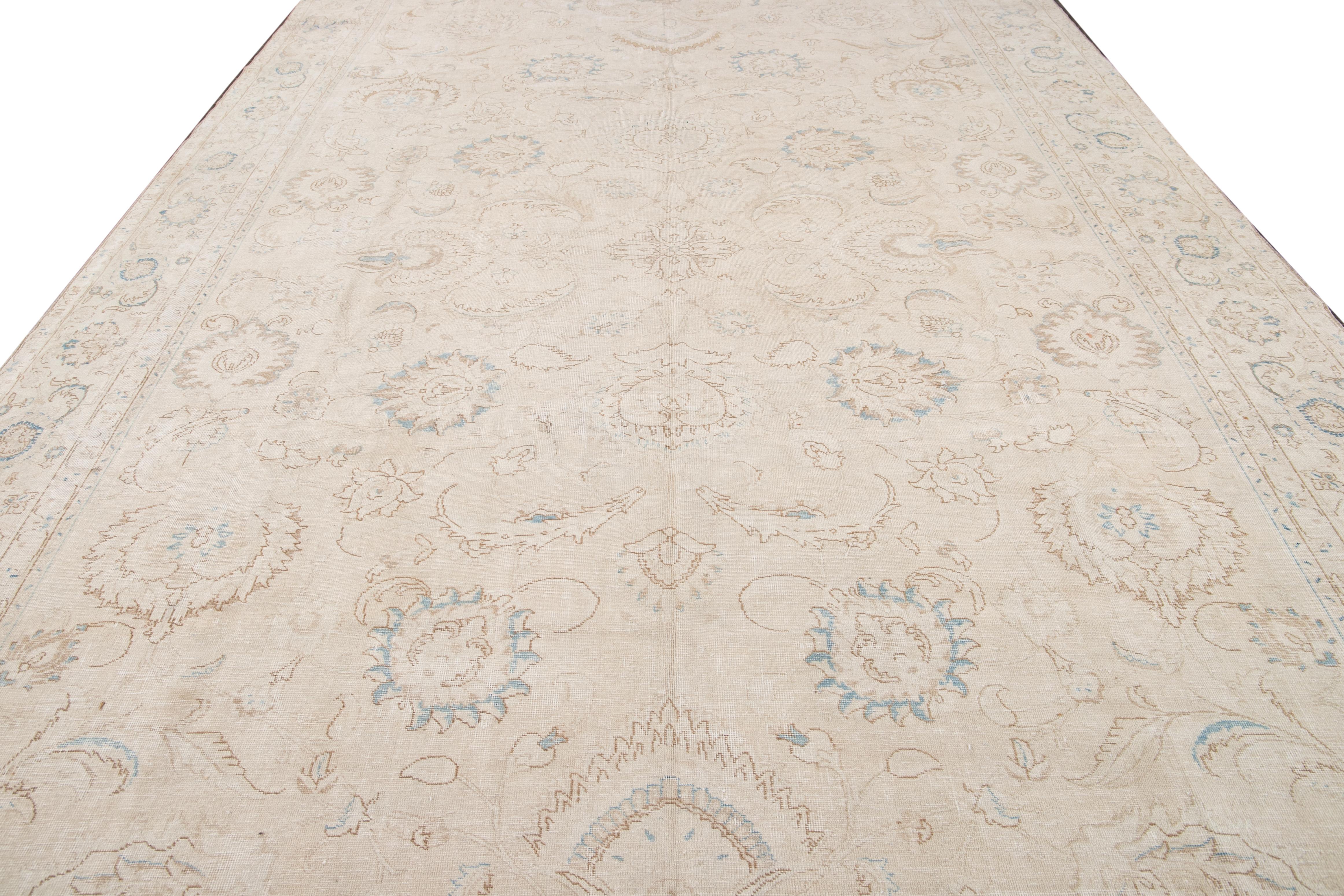 Beautiful antique Tabriz hand-knotted wool rug with a beige color field. This Persian rug has a blue and brown accent in a gorgeous all-over Shah Abbasi design.

This rug measures: 10'2