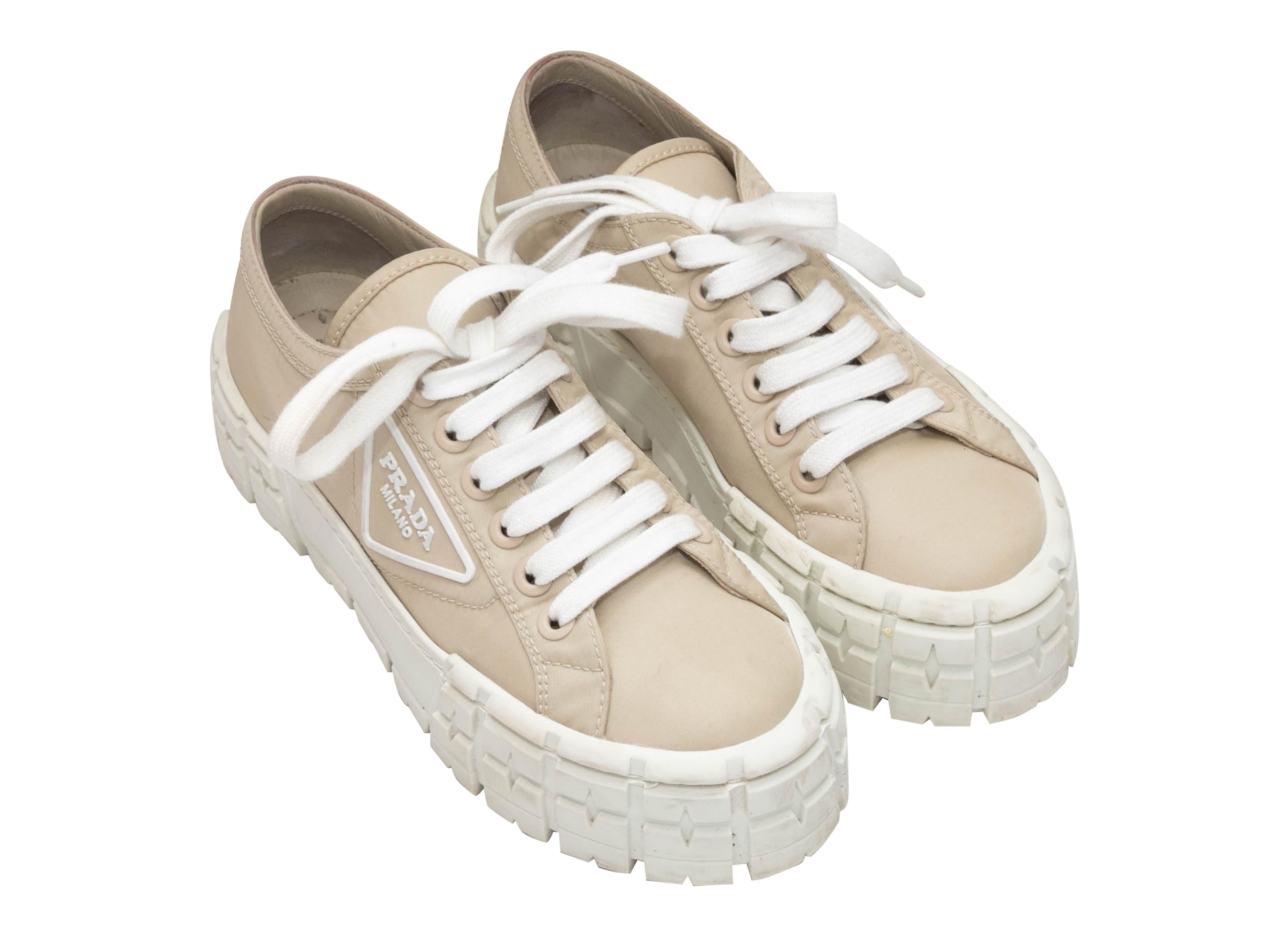 Beige and white Double Wheel Re-Nylon platform sneakers by Prada. Rubber soles. Lace-up tie closures at tops. 2