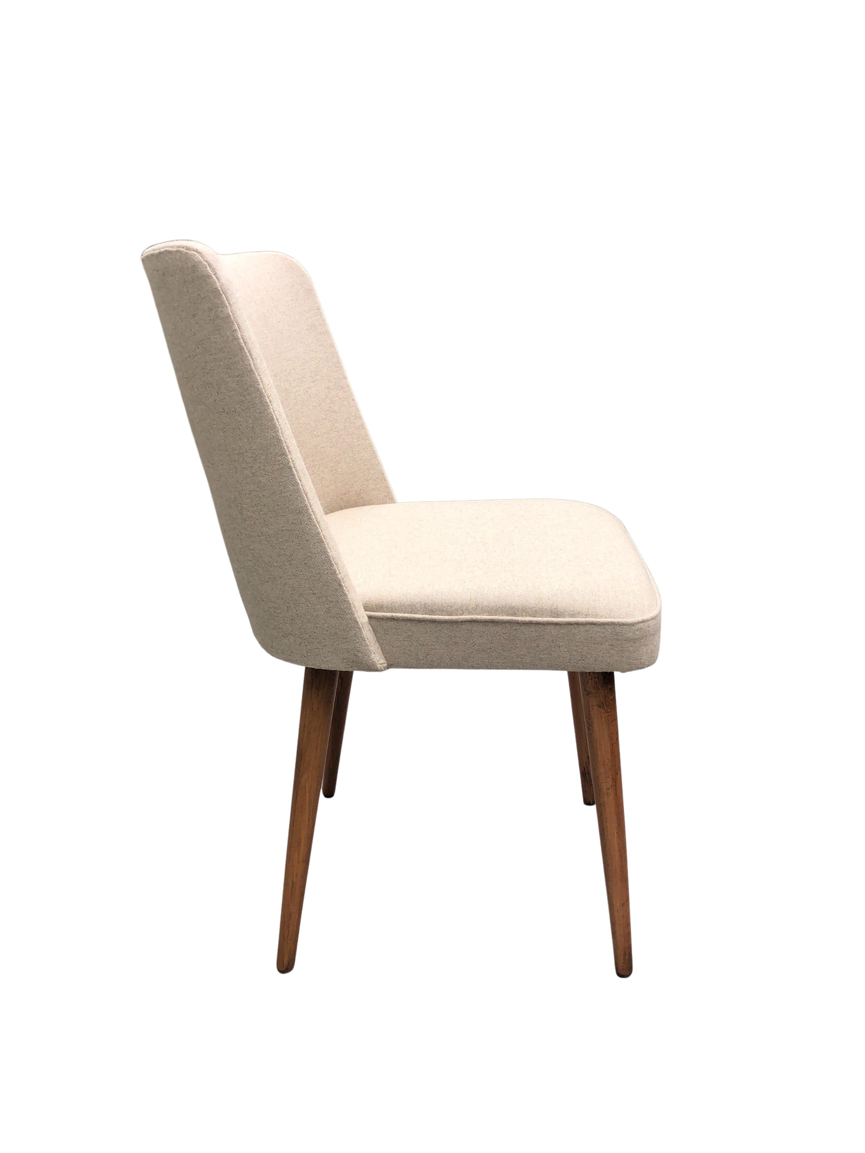 Beautiful dining chair with a modernist silhouette, design around 1962, manufactured by Slupskie Fabryki Mebli in Poland. The structure is made of plywood and beech wood. The upholstery is made of a high quality wool in beige color. The chair has