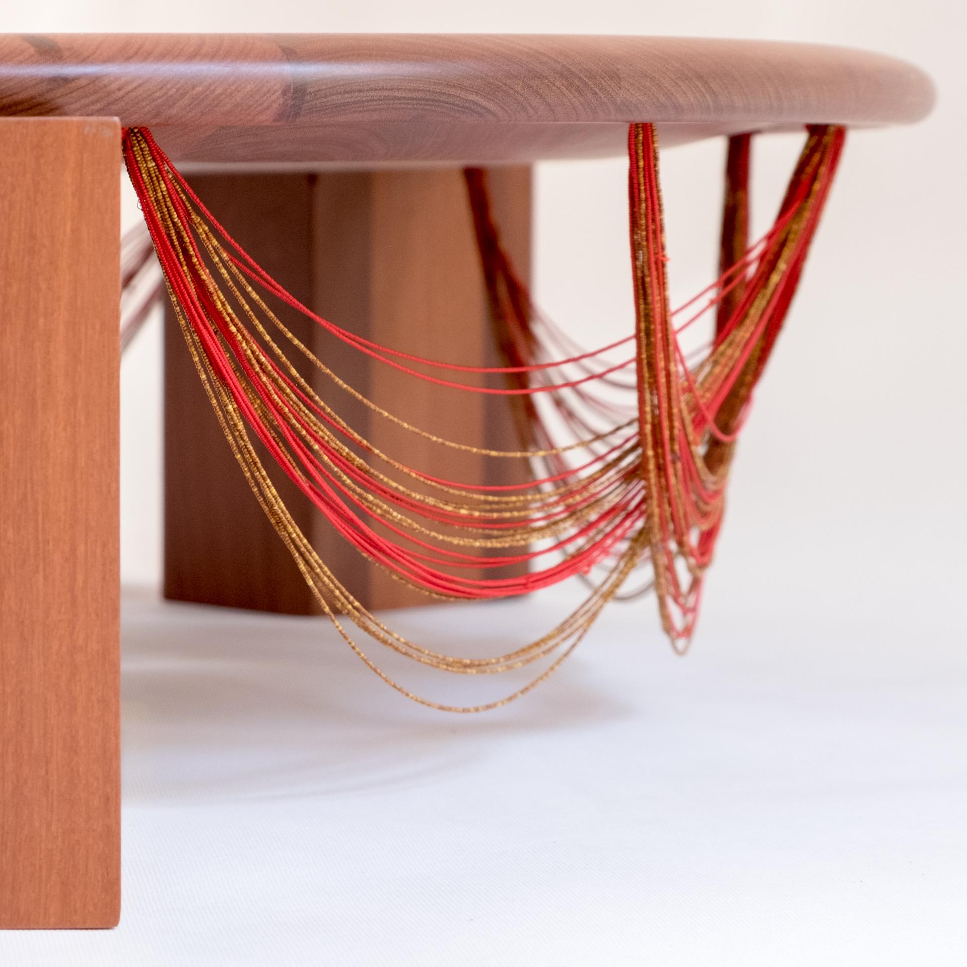 La table centrale Beiju est un hommage aux femmes indigènes Mehinaku. Fabriquée en bois de Cabreúva, elle reçoit de minuscules colliers de perles fabriqués par les autochtones pour être utilisés dans les rituels traditionnels de leur peuple, dans le