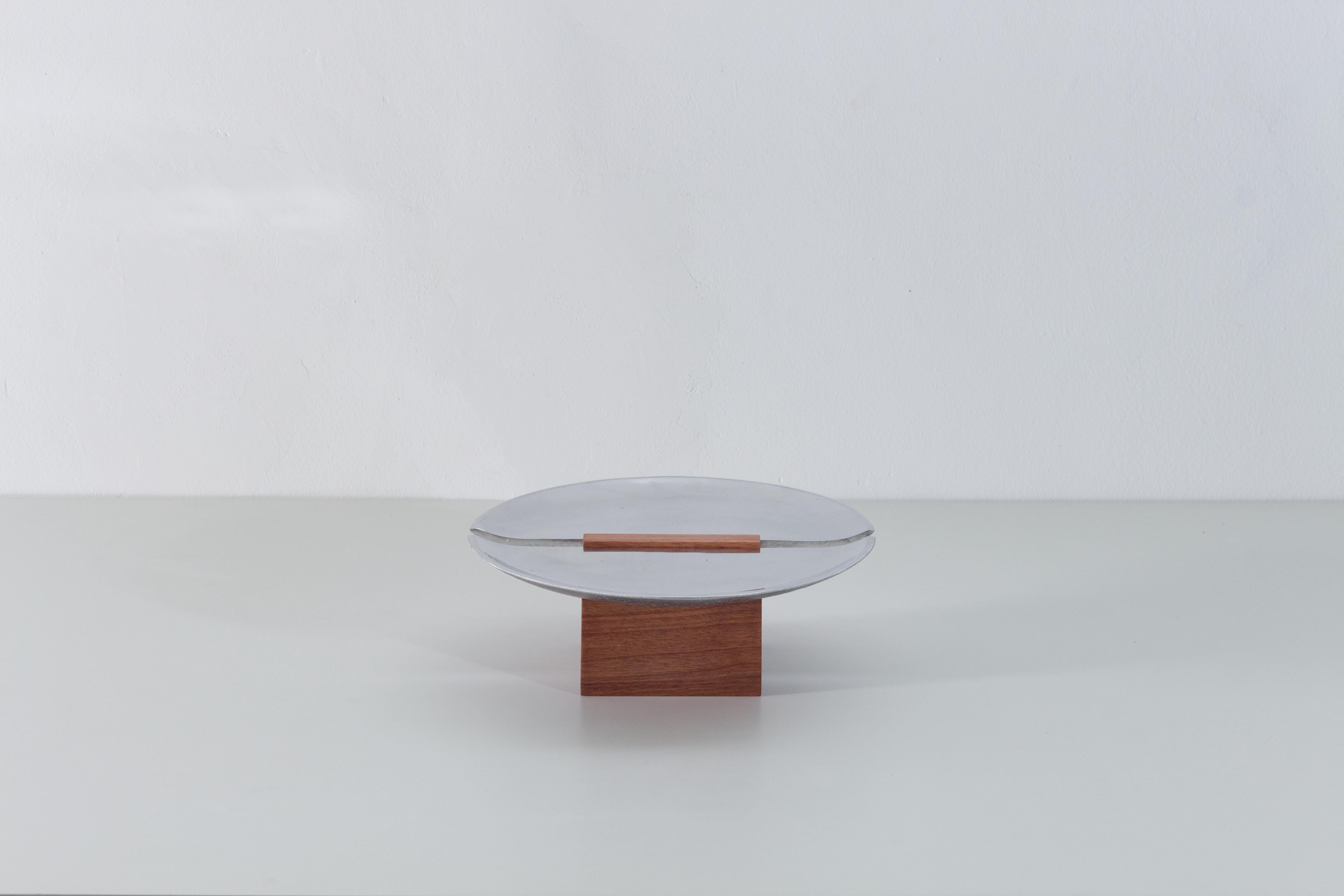 Winner of the 2023 EDIDA Brazil (Elle Deco International Design Awards) in the Objects Category.

Beira is a collection of centerpieces defined by geometric wood and metal elements. A cut divides the metal surface in two and, in between them, the