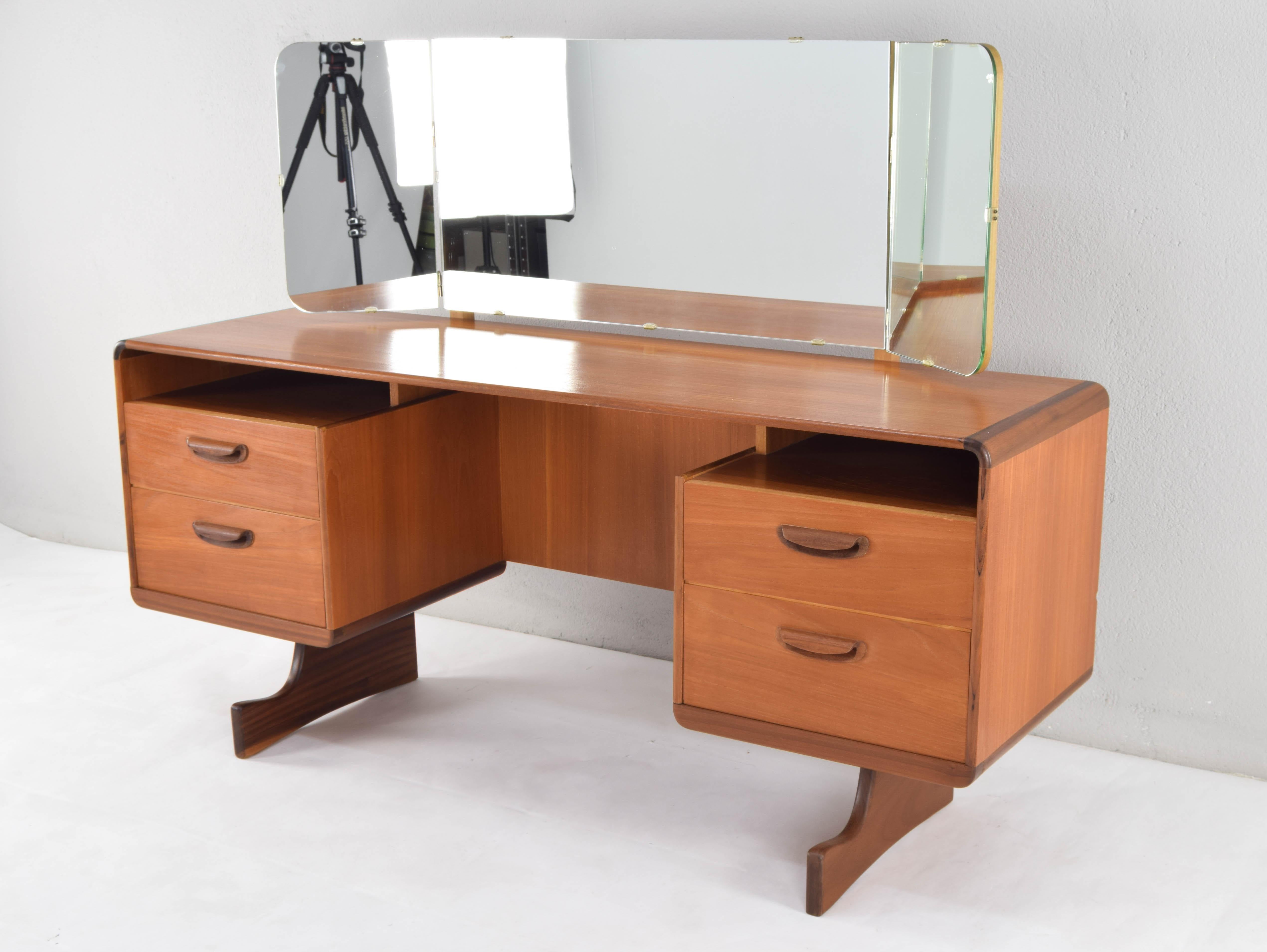 Teak wood dressing table with triptych mirror. Spectacular piece with fluid organic lines, with curved angles and sculpted handles, manufactured by the Scottish cabinetmaker Beithcraft.

This piece, in addition to being one of the best and most