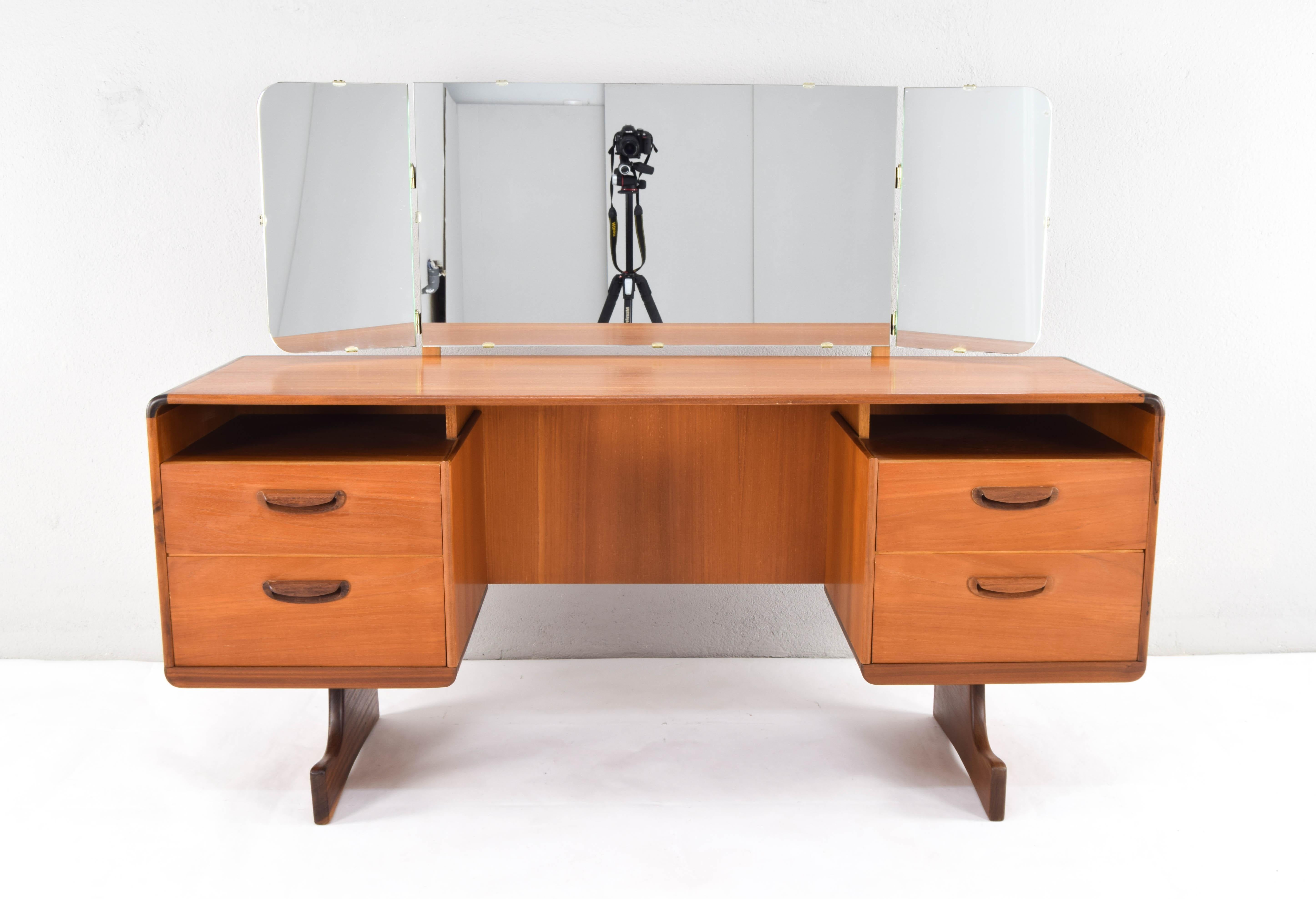 Teak wood dressing table with triptych mirror. Spectacular piece with fluid organic lines, with curved angles and sculpted handles, manufactured by the Scottish cabinetmaker Beithcraft.

This piece, in addition to being one of the best and most
