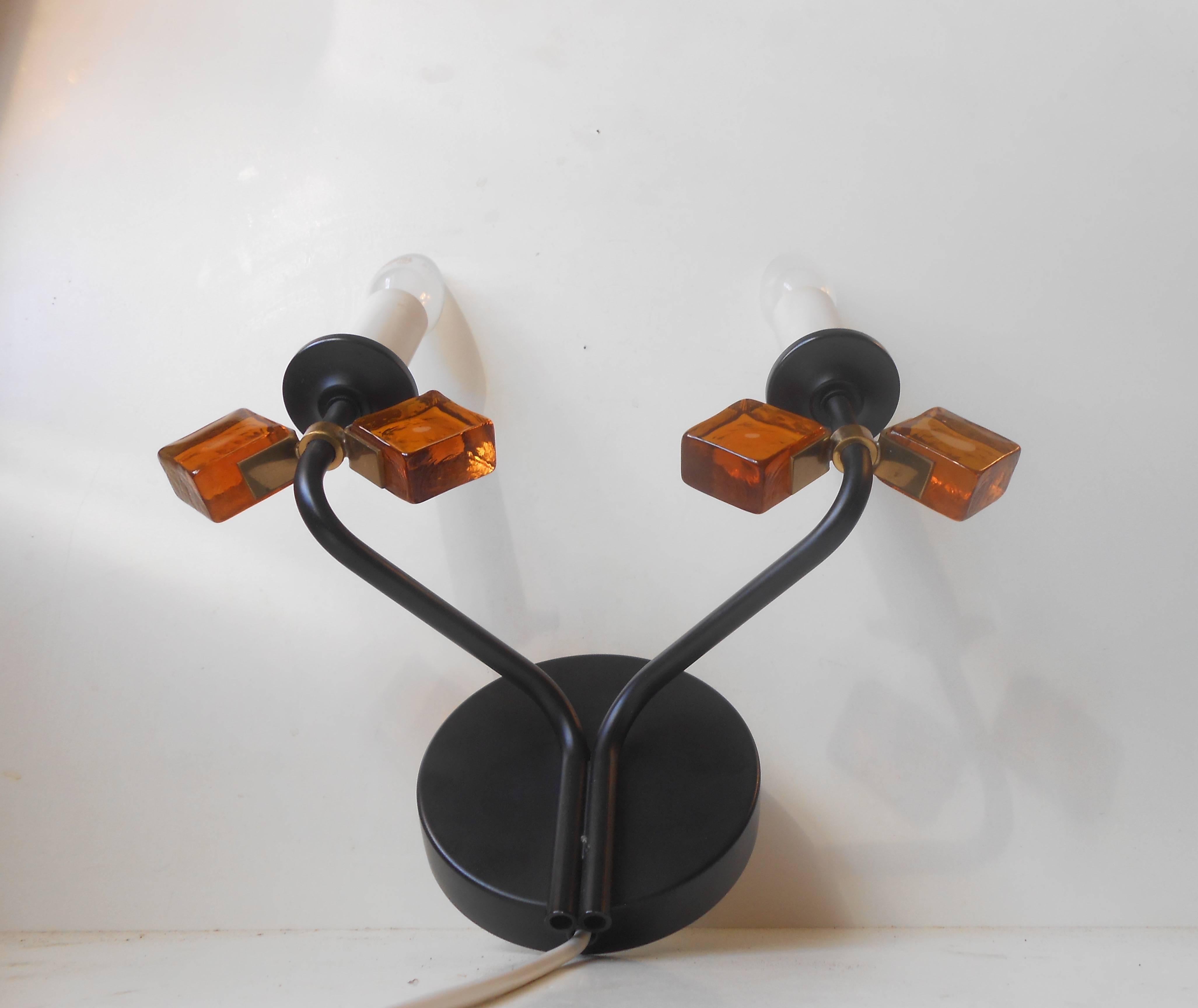 Black-bodied sconce by Holm-Sorensen with rotating brass and amber glass butterfly-shaped settings. Original sticker to the backside. Measurements (approximate): H 12 inches, W 10 inches.