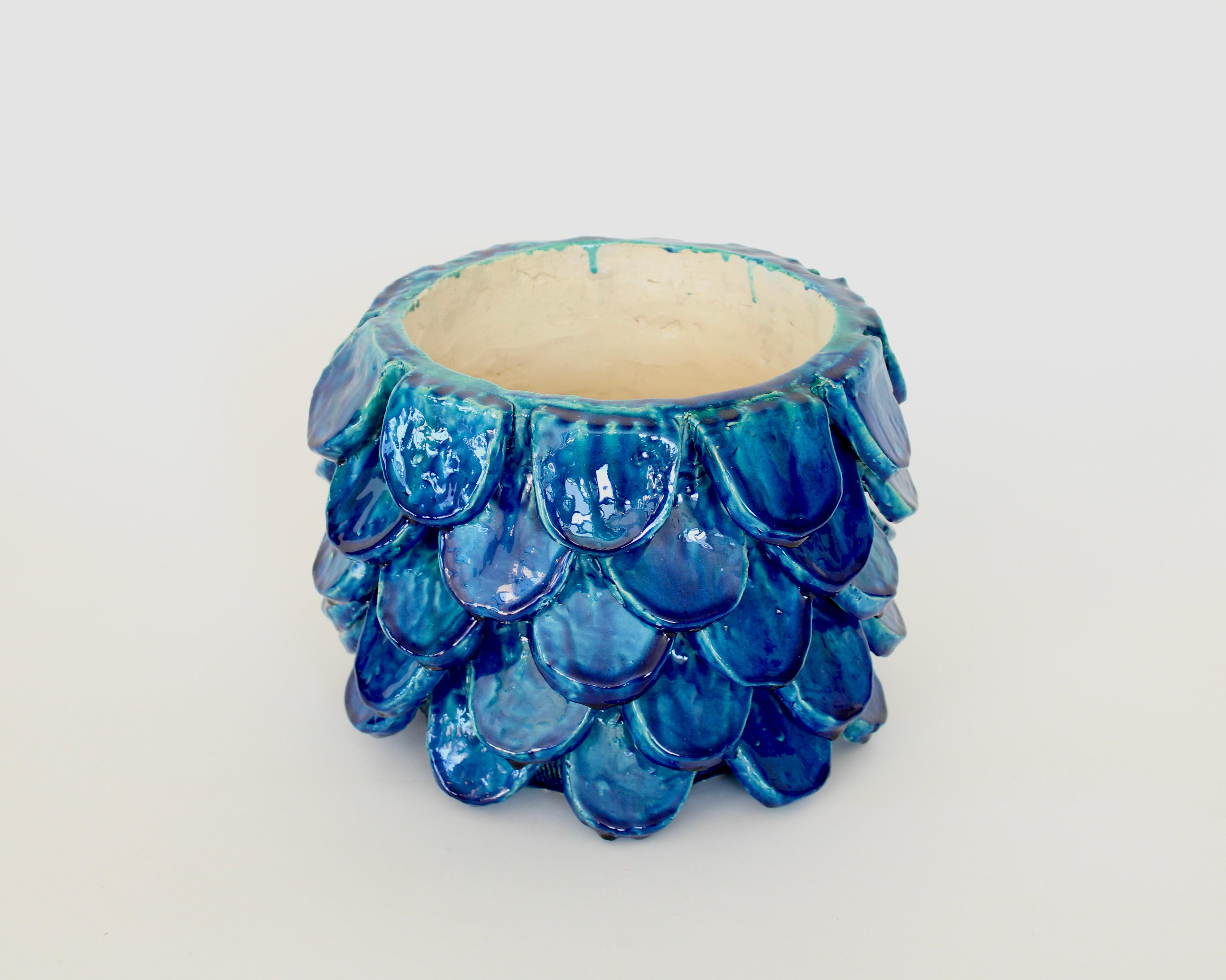 Contemporary artist Bela Silva piece unique sculptural floral motif handmade ceramic vase.
This vase is in a vibrant blue that is actually layers of blues that she uses to achieve the colors that she favors in all her work.
It is sculpted and