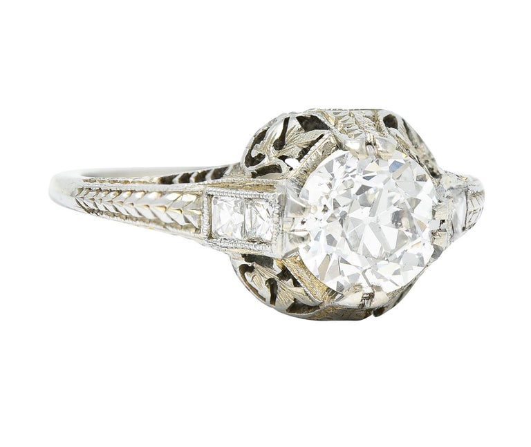 Centering an old European cut diamond weighing approximately 1.19 carat - G color with SI2 clarity

Set by stylized split prongs engraved with a foliate motif

Shoulders are set with French cut diamonds weighing approximately 0.20 carat - well