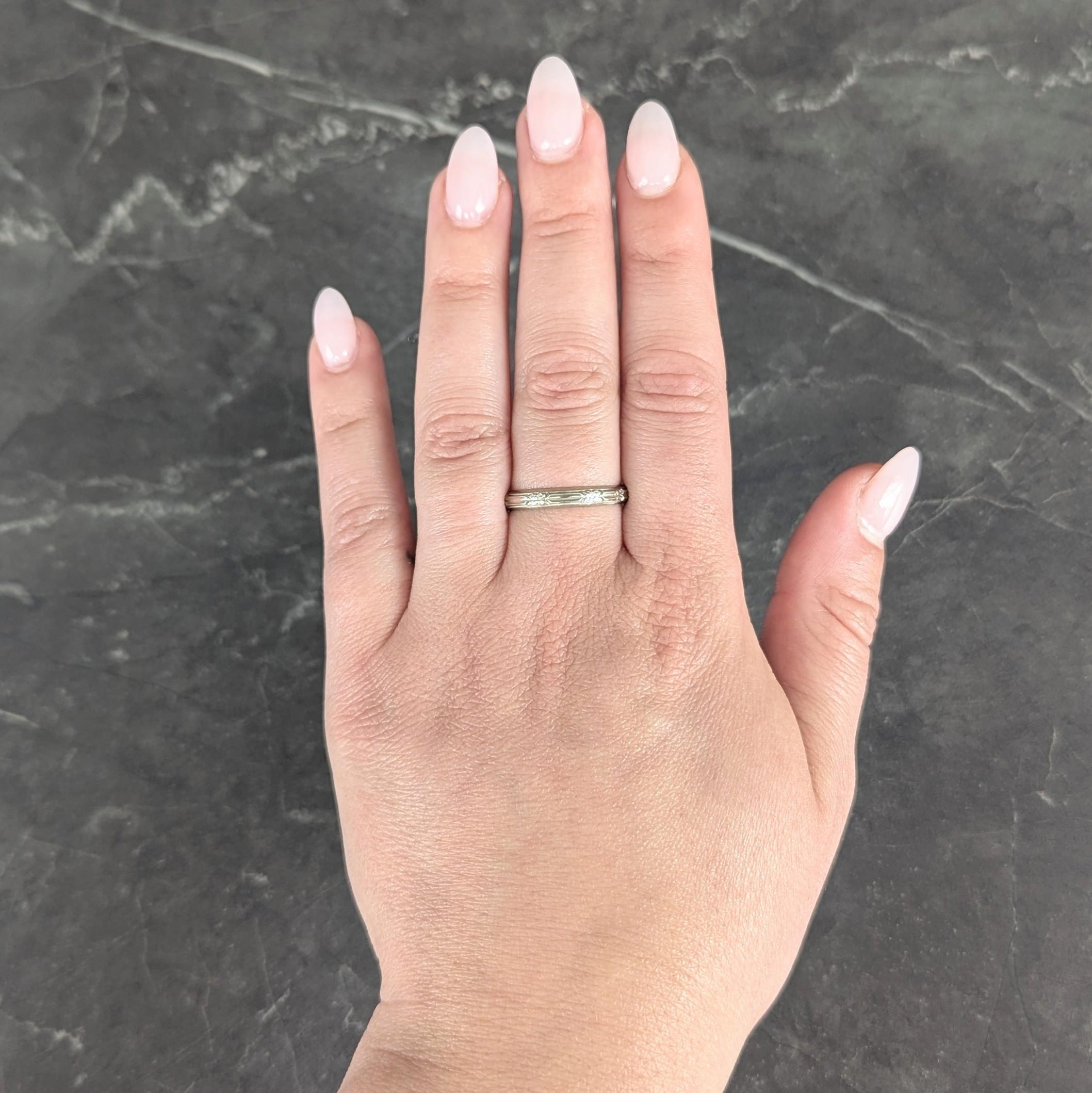Featuring a raised orange blossom motif fully around
With grooved detail on flowers and foliates
Accented by milgrain edges
Stamped for 18 karat gold
Signed for Belais
Circa: 1930s
Ring size: 9 1/4 and sizable
Measures north to south 3.0 mm and sits