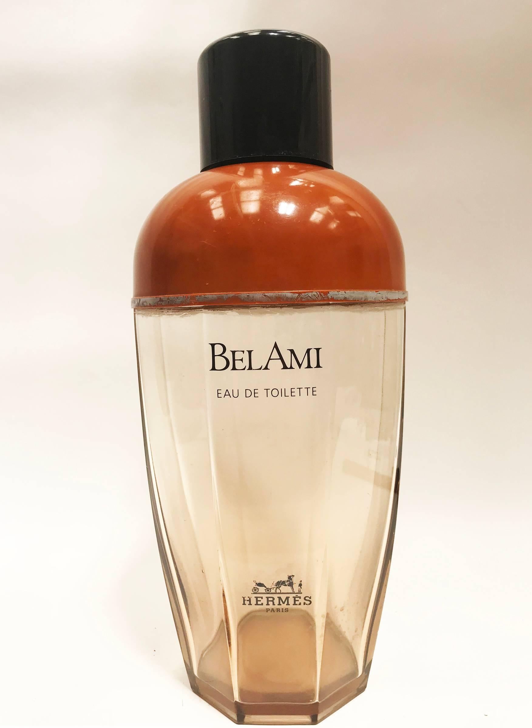 Flacon de parfum Factice, Bel Ami de Hermés. Sorte de verre rose à facettes avec le nom du parfum et le logo de la marque sur la face avant, le dessus a un couvercle en bakélite de couleur rouge Sienne et le capuchon est en bakélite noire et ivoire
