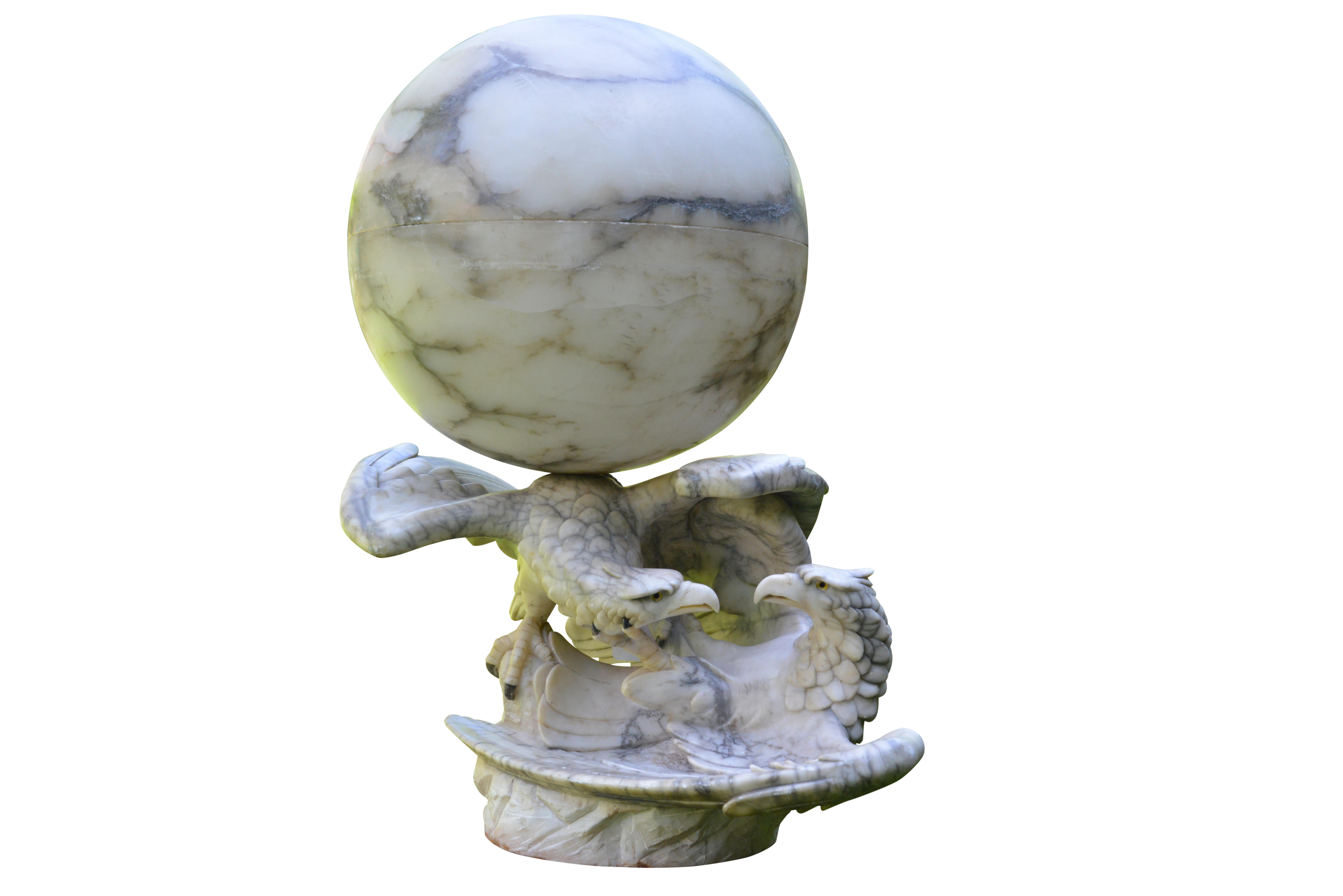 Extremely impressive table lamp with two frolicking eagles supporting a huge illuminated sphere. Beautifully carved in the finest alabaster on a rock imitation plinth.