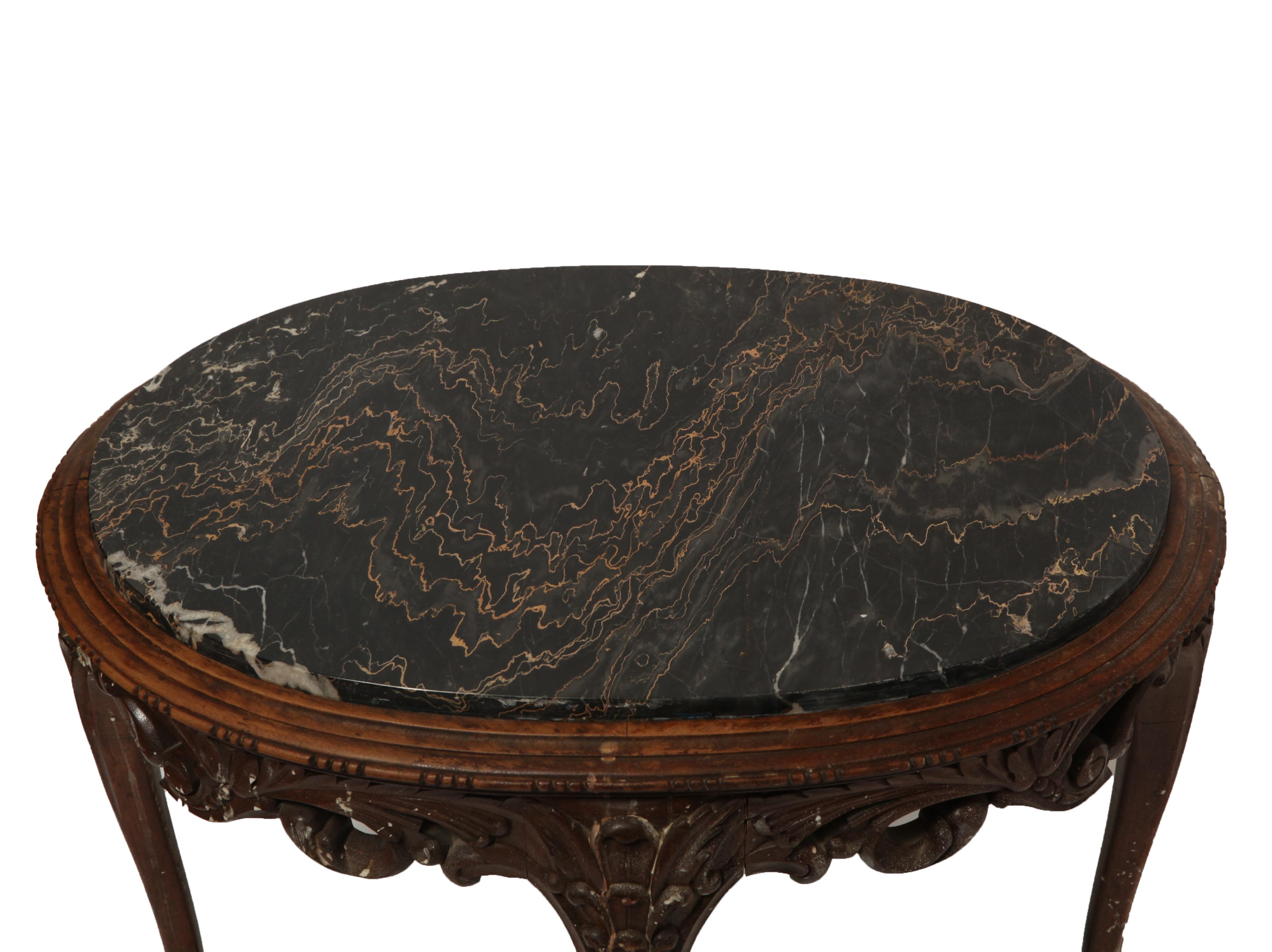 Belgian Art Nouveau oval side table in carved wood. The piece has an oval veined marble top and a 'Made in Belgium' label on the bottom. I great antique condition with age-appropriate wear and use.