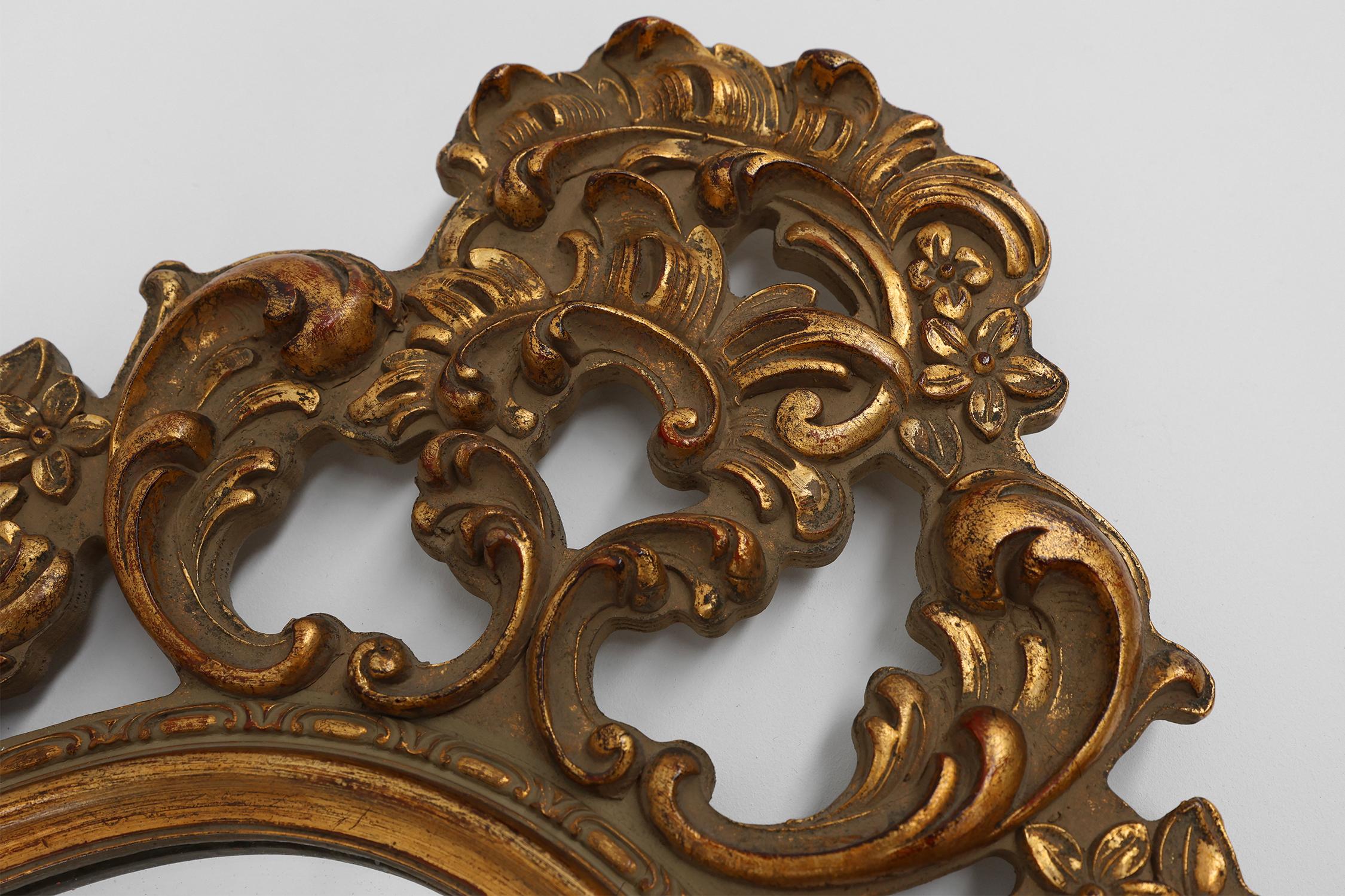 Belgium / 1950 / Mirror / wood / Baroque / Mid-century / Vintage

Baroque Belgian wall mirror with gilded frame. This beautiful mirror has a rich decorations all around the mirror and a nice antique look.

This golden mirror showcases a harmonious