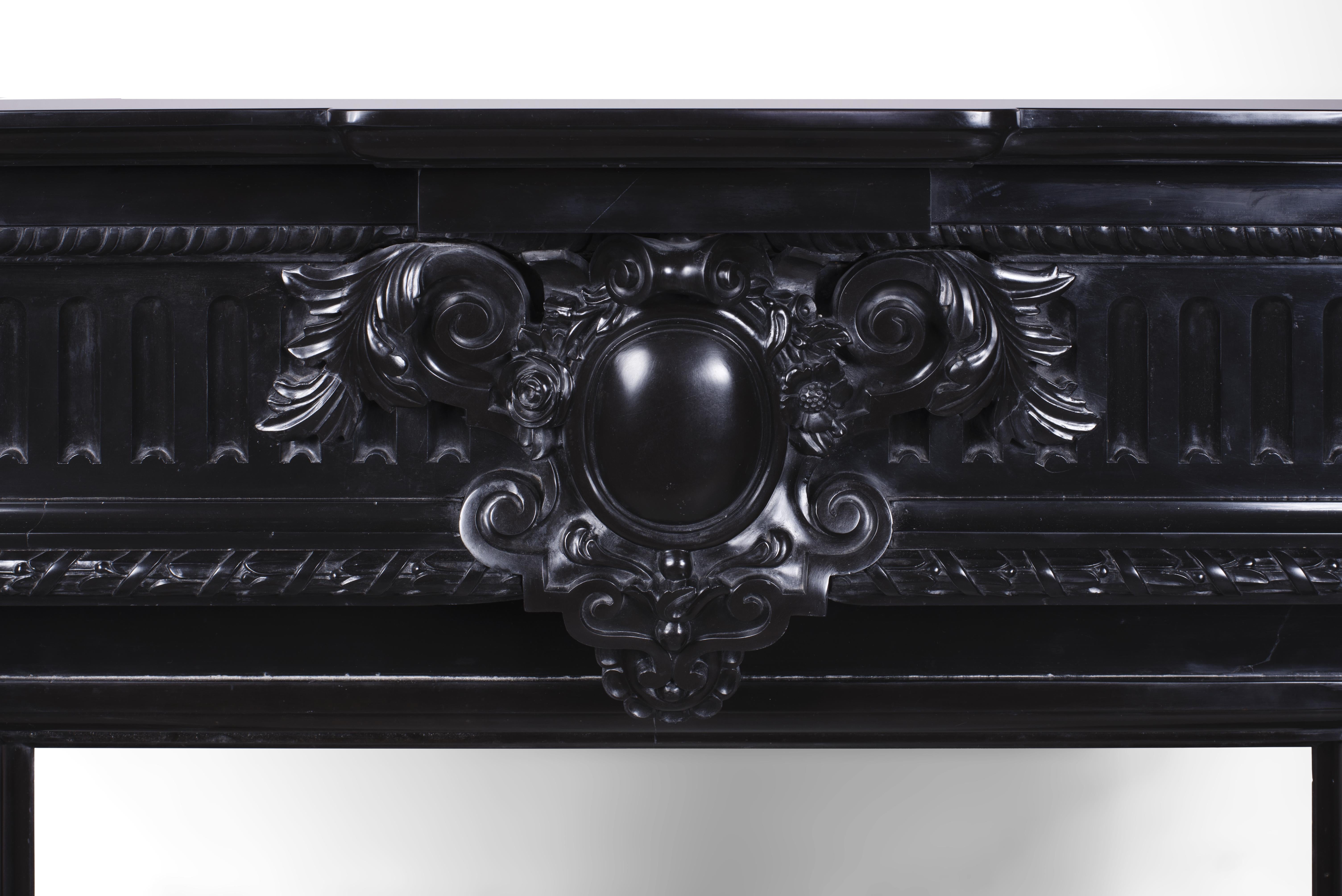 This beautiful antique Napoleon III style mantel was made in Belgium in the second half of the 19th century. It is a rare and strong piece because of its carved decoration in a very beautiful Fine Black marble from Belgium. It is a rare and large
