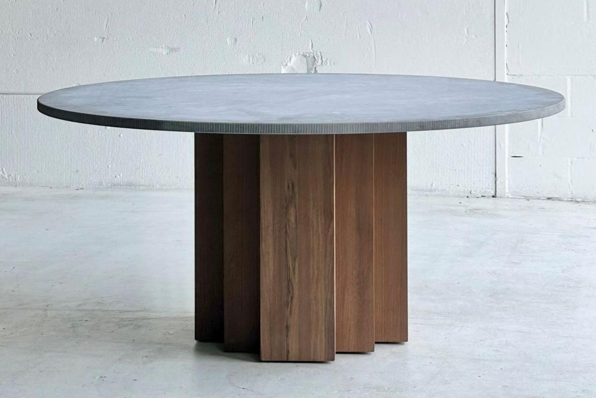 A substantial indoor/outdoor table defined by its clean lines, sculptural base, and timeless modern design. Handmade with care, it features a long-lasting Belgian Bluestone top resting on a solid Fraké wood base.

Fraké wood, also known as Limba, is