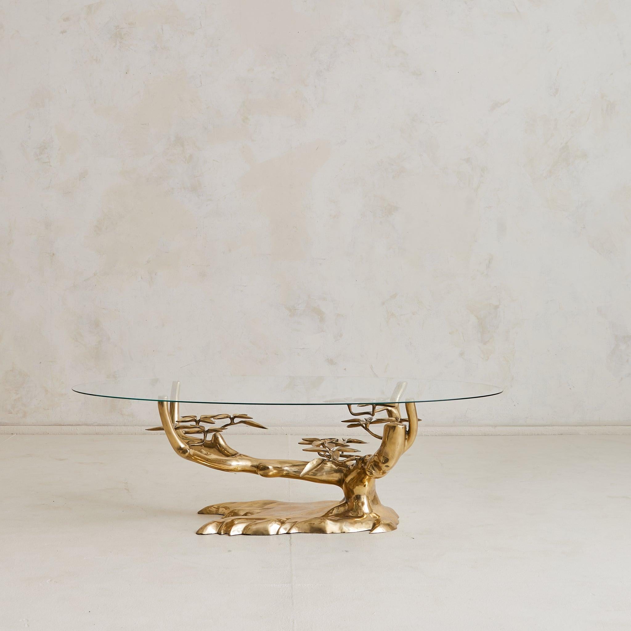 A 1970s Belgian coffee table by Willy Daro, defined by its sculptural brass base shaped like a bonsai tree. An ellipse shaped glass top rests above the intricate base.

Willy Daro, born in Belgium in 1918, was known for his botanical and floral