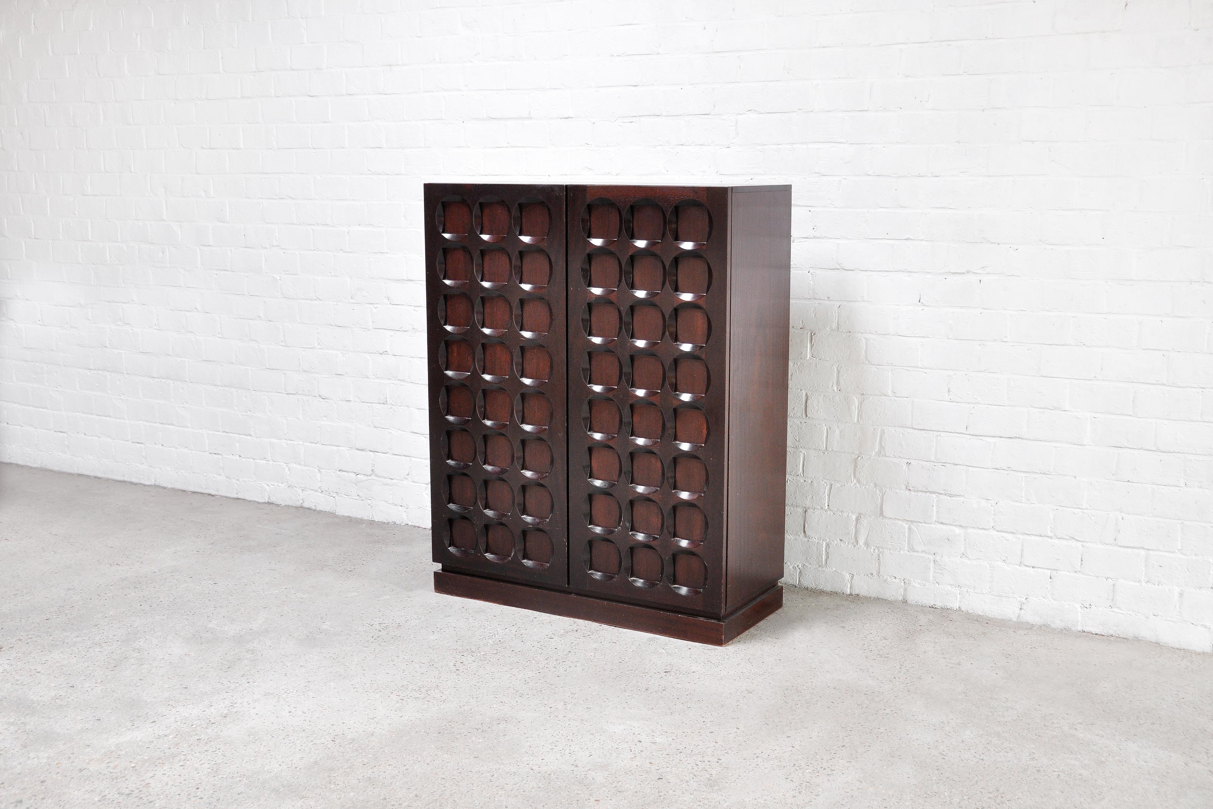 A stunning dark brown brutalist/modernist bar cabinet with graphical doors. The continuous pattern gives this sideboard a strong and eye catching expression. Shows amazing woodwork on the two-door panels. The oak wood is stained into a dark brown