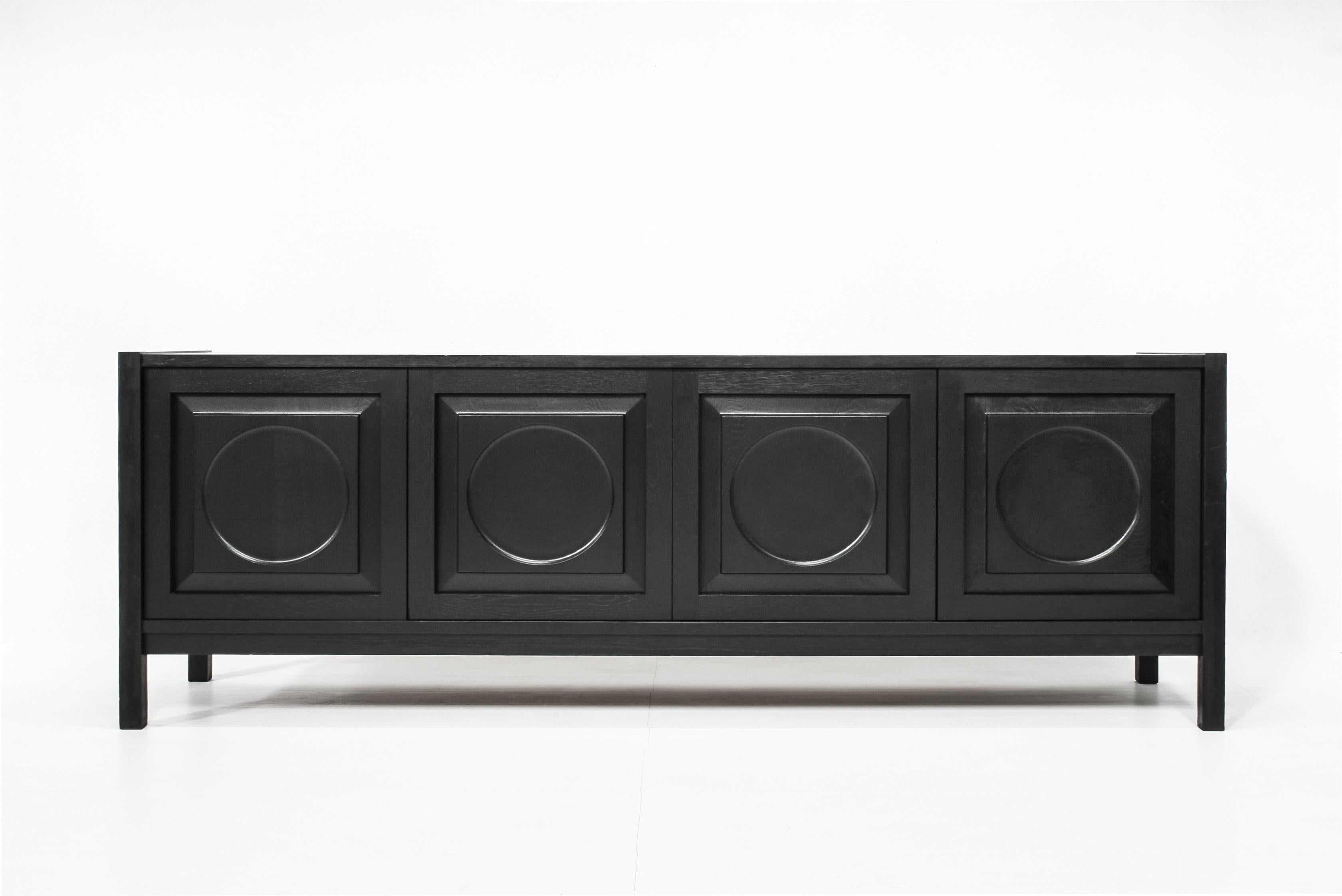 Beautiful brutalist sideboard with four abstract circle doors in ebonized oak.

The second door hides four drawers.