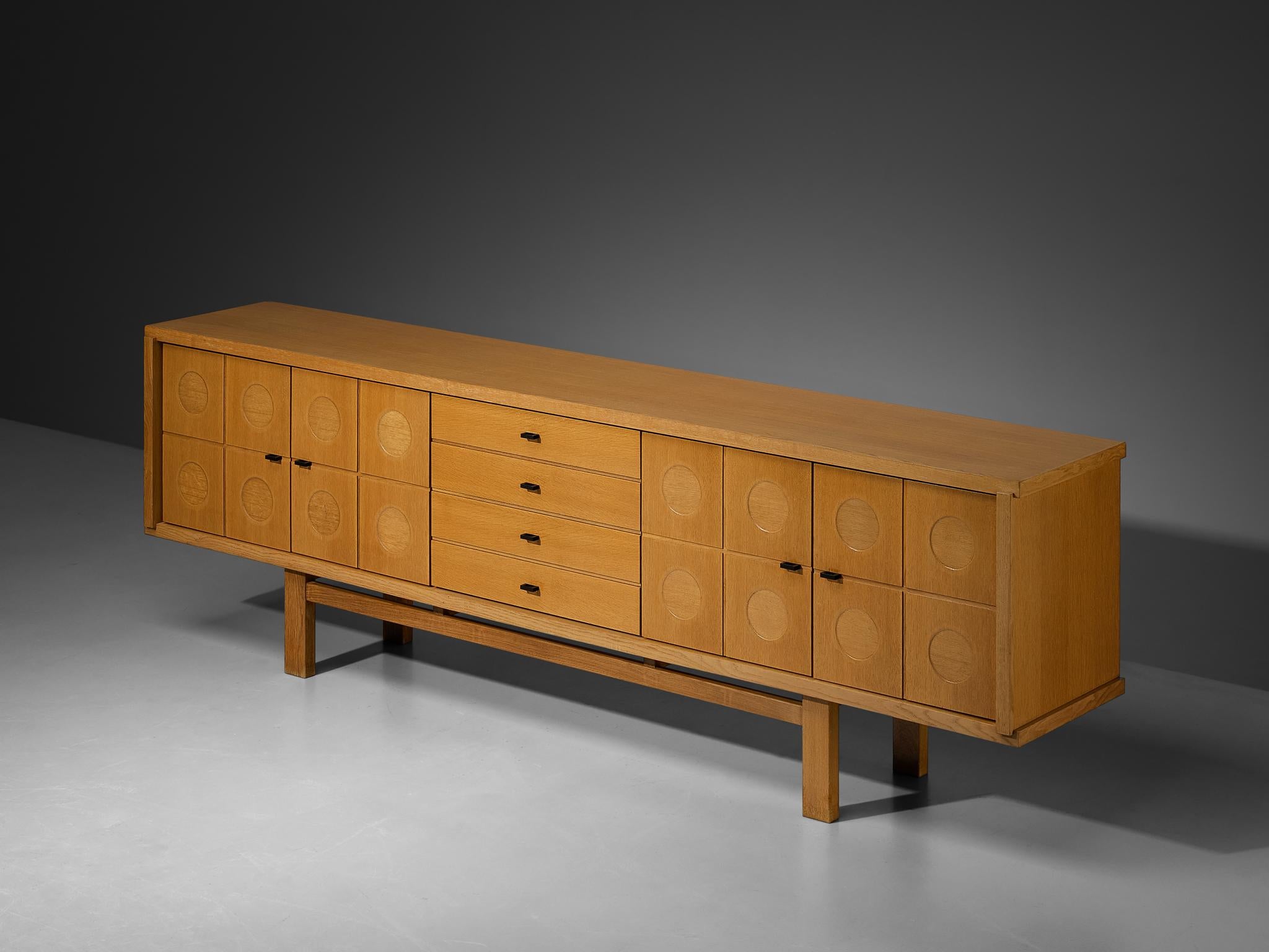 Buffet, chêne, aluminium laqué, Belgique, 1970

Ce buffet présente un rythme et un flux clairs, établis grâce à une mise en page bien pensée et tout à fait équilibrée. Les cercles sculptés attirent immédiatement l'attention et sont la signature de