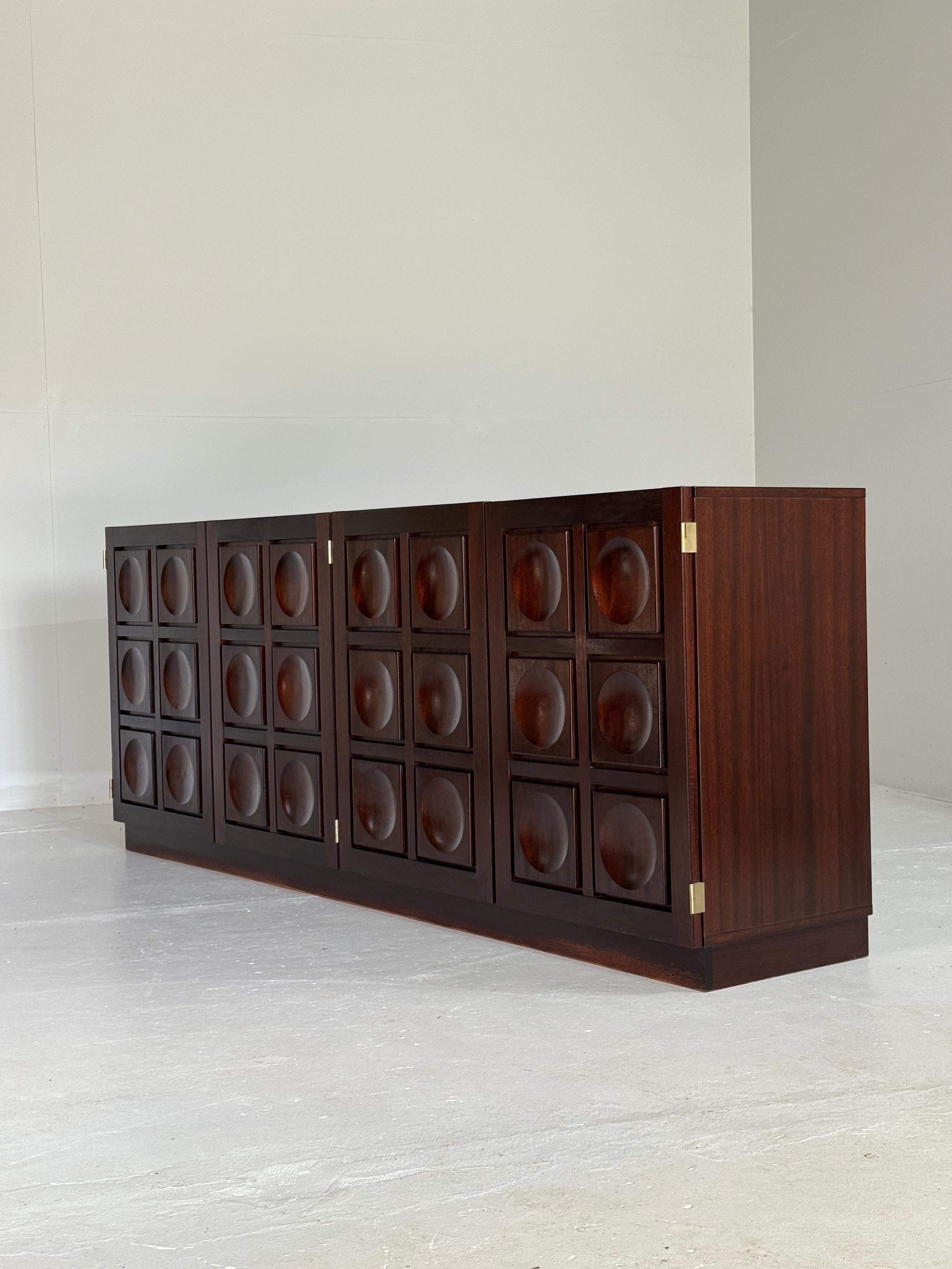 Sideboard/credenza in stained mahogany, belgium, 1970s.

It's a 4-door beauty made of rich, stained mahogany, and it's a true masterpiece of Belgian Brutalist design. The clean lines, minimal ornamentation, and sturdy construction all come together