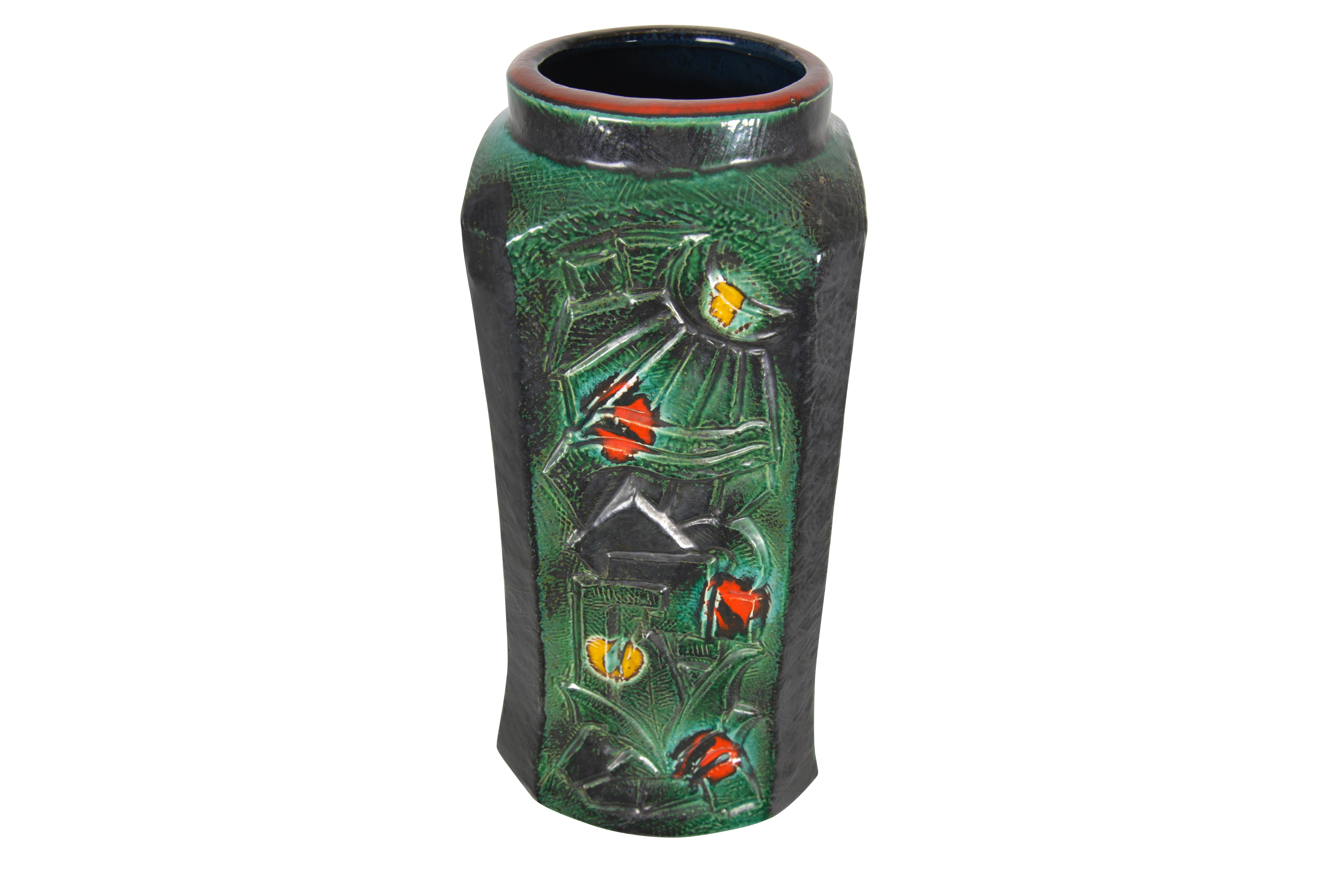 Delicately green patinated vase with on three sides Art Deco stylized patterns and on the main side a deco palmtree and sunburst. Scattered yellow and red accent dots. Marked 234/46.