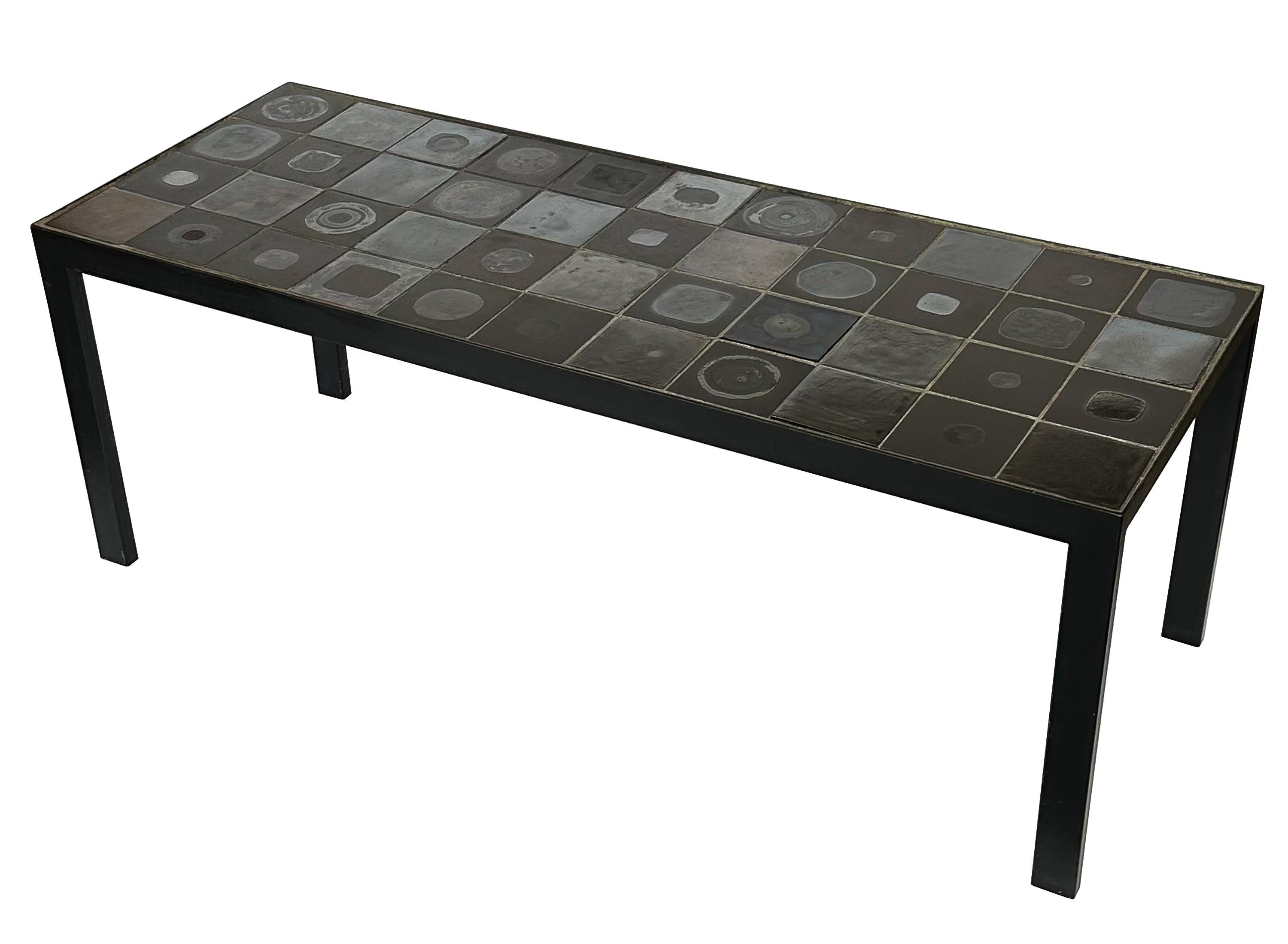 A Belgian ceramic tile top coffee table (signed), Belgium circa 1960s. This narrow coffee table features a black painted steel frame inset with 44 handmade metallic glazed ceramic tiles in a simple grid. Each tile is unique and measures